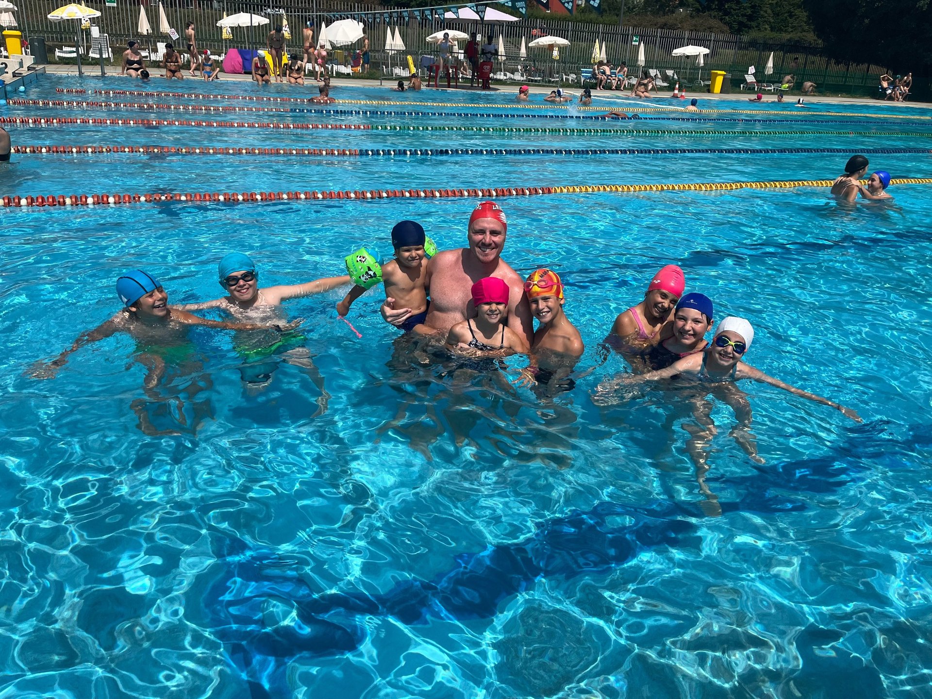 child holding four food packs beside red wall