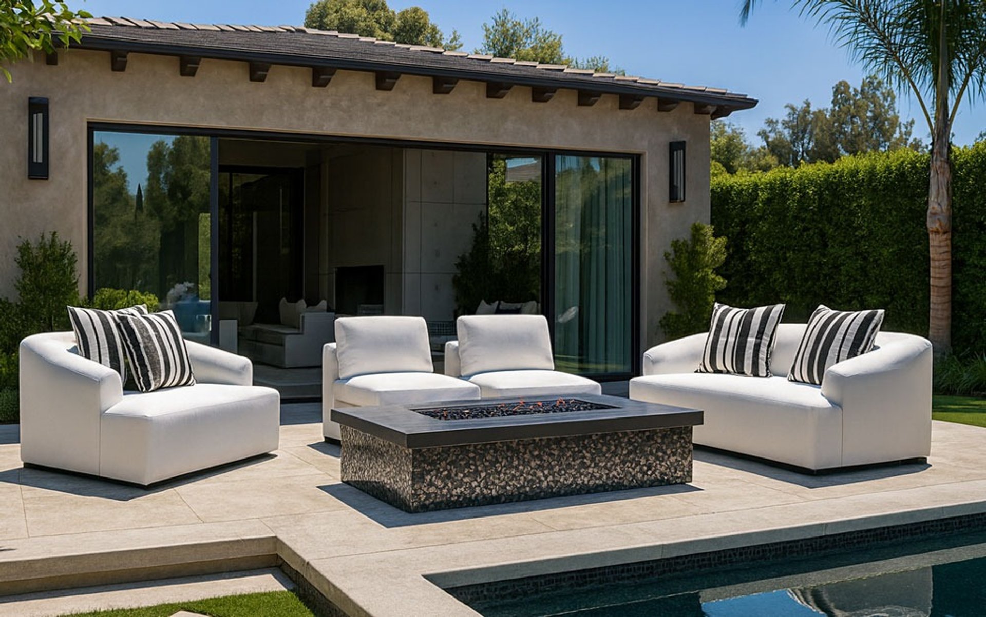 Elegant white sofa set by Solo Home Decor near a pool with striped pillows, showcasing a modern luxury backyard design.