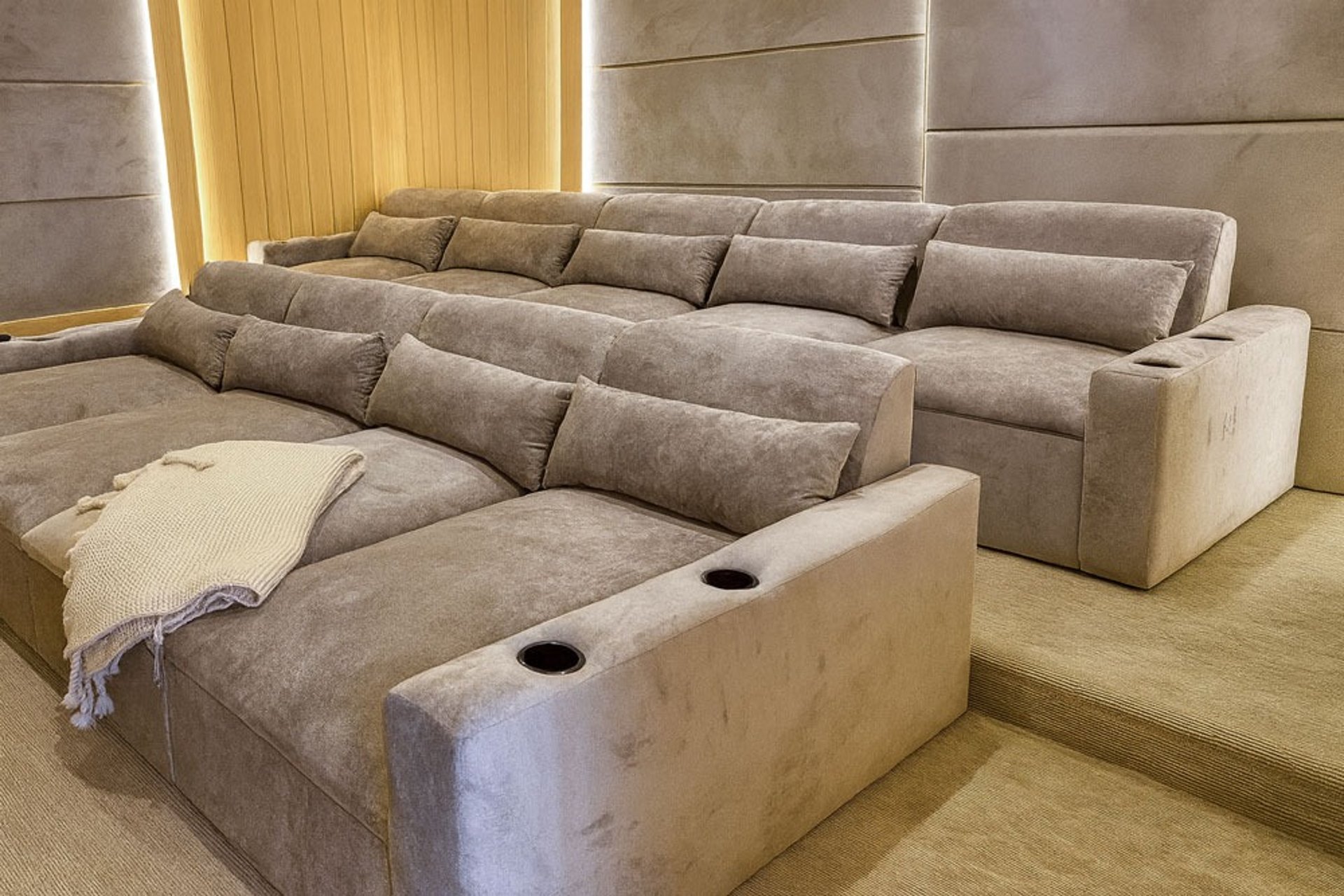Solo Home Decor custom theater sectional with plush reclined seats, cup holders, and warm lighting