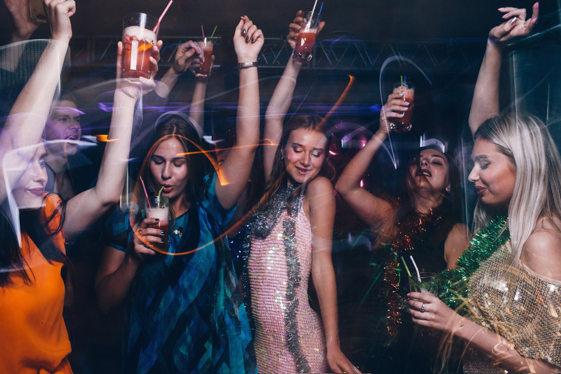 Women enjoying a wild night out on a Las Vegas bachelorette party bus club crawl with drinks and dancing.