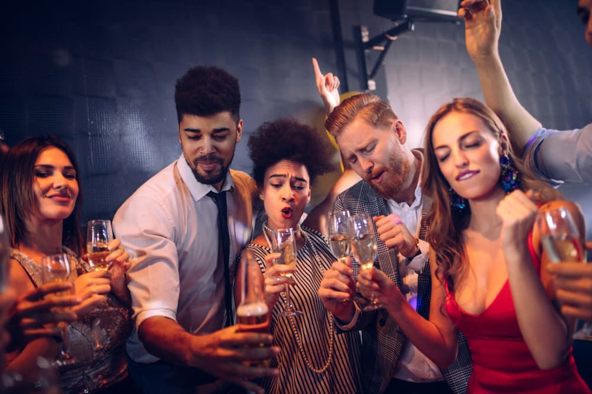 Group of friends partying with drinks during a Fremont Club Crawl in Downtown Las Vegas