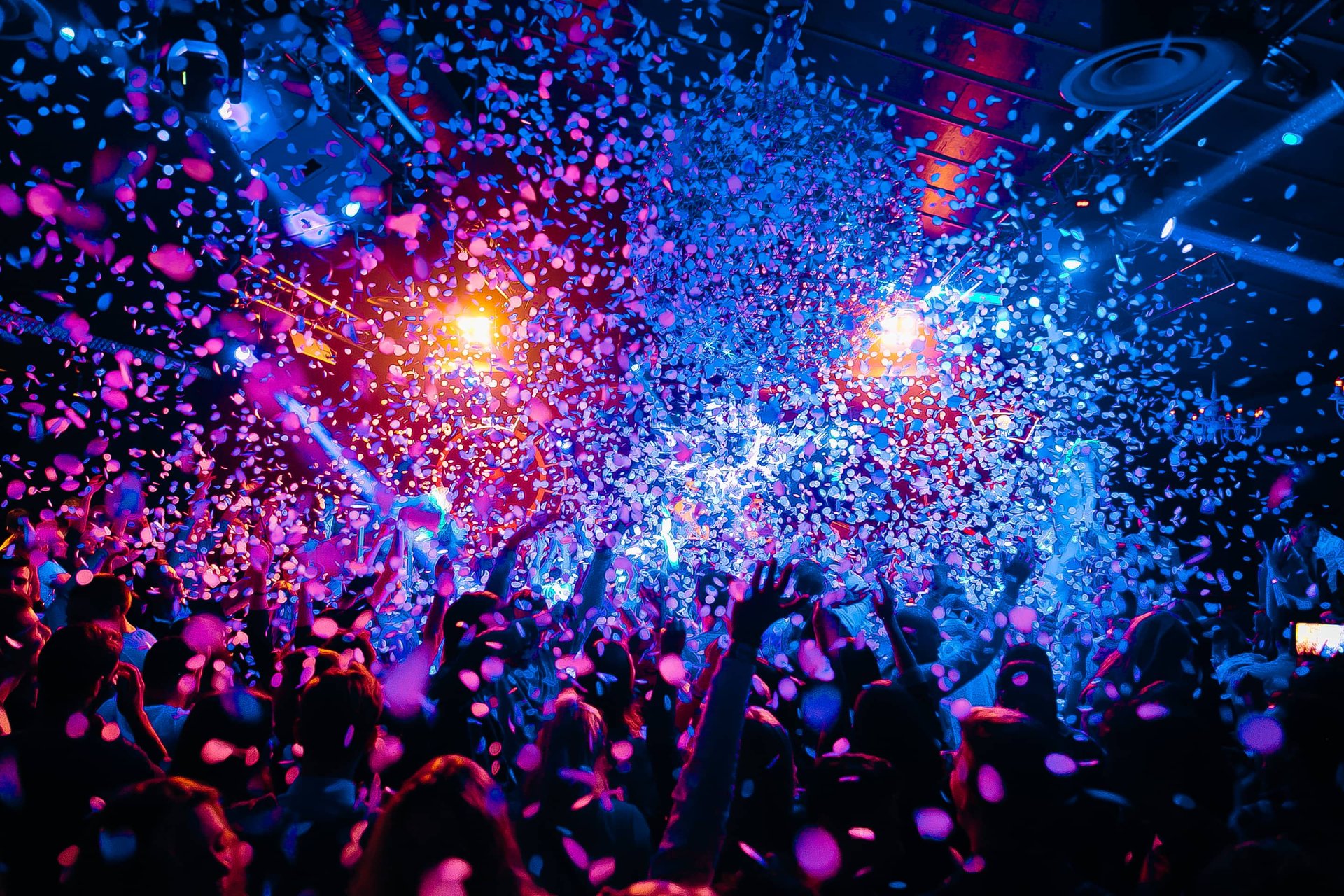 Colorful confetti falling in a lively Las Vegas nightclub with a dancing crowd and vibrant lighting.