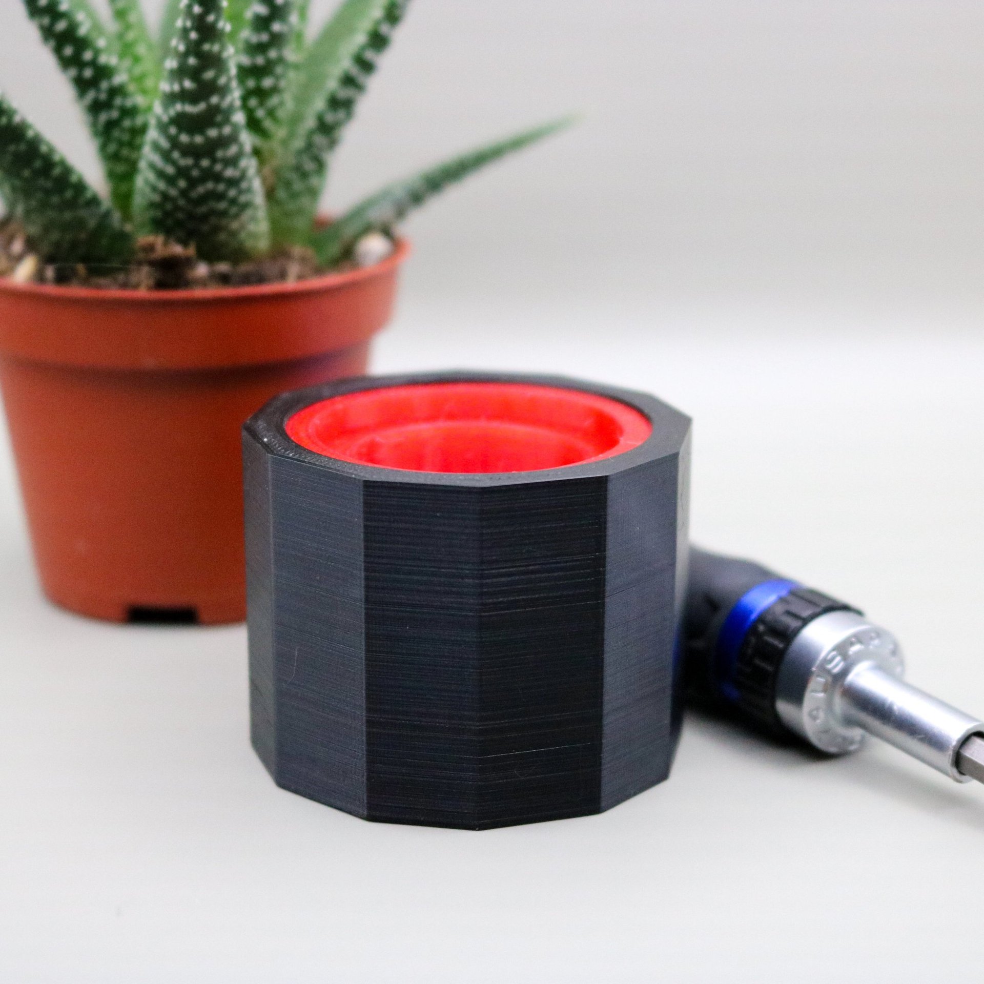 A black 3d-printed tray with hexagon cutouts.