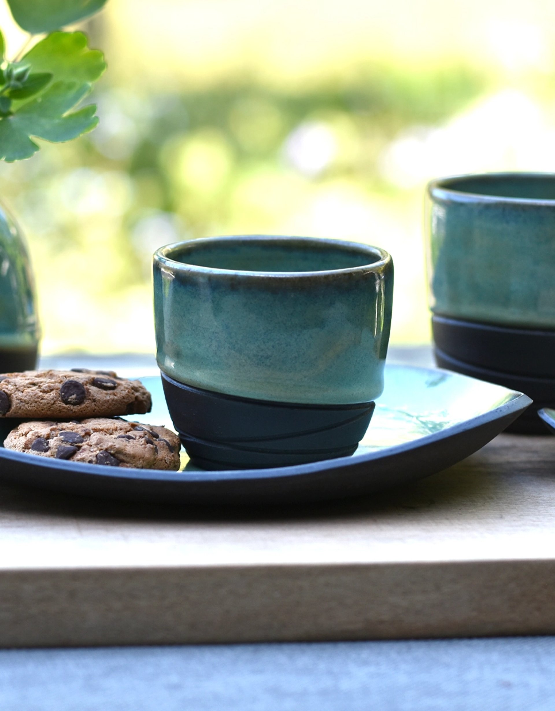 Handgemaakte keramieken koffiekopjes met schoteltje zwarte steengoed klei met sage groene glazuur