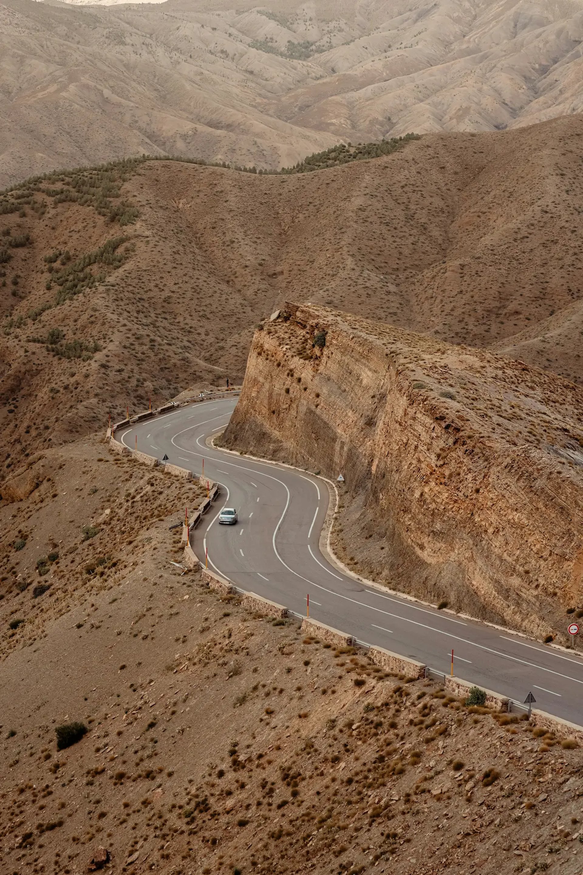 a car driving down a winding road in the mountains