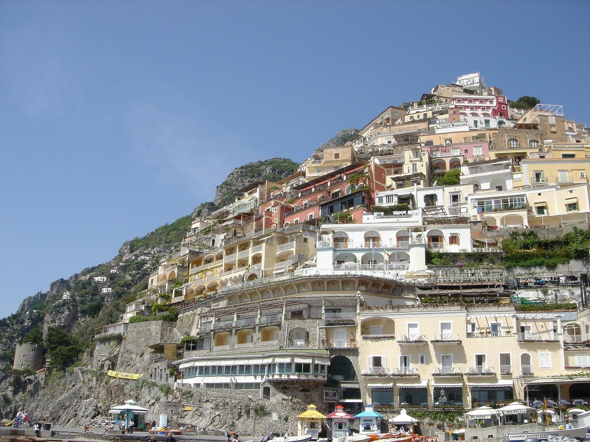 Colorful cliffside homes and hotels cascading down the hillside in Positano on Italy’s Amalfi Coast, viewed from the beach
