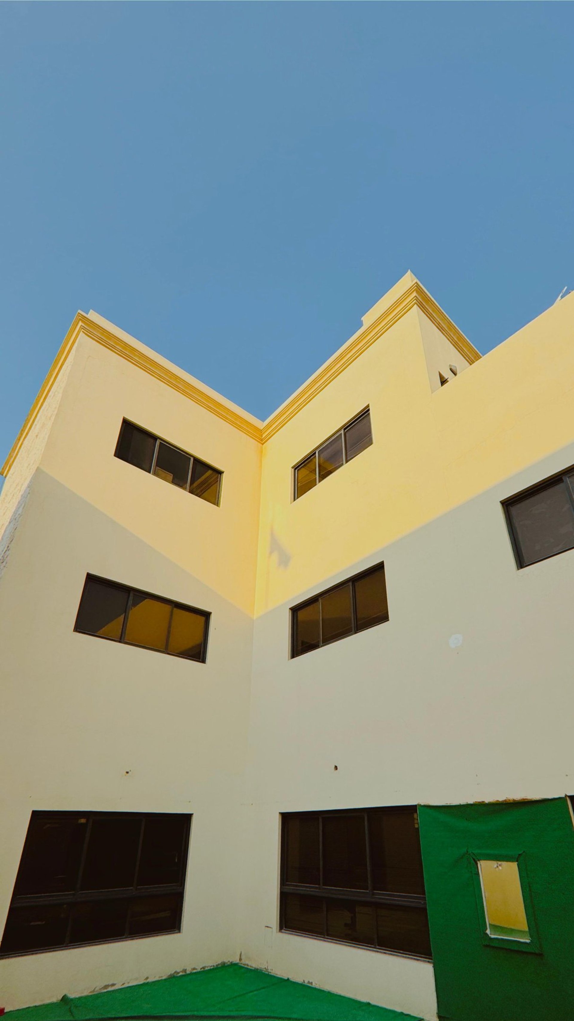 an abstract photo of a curved building with a blue sky in the background