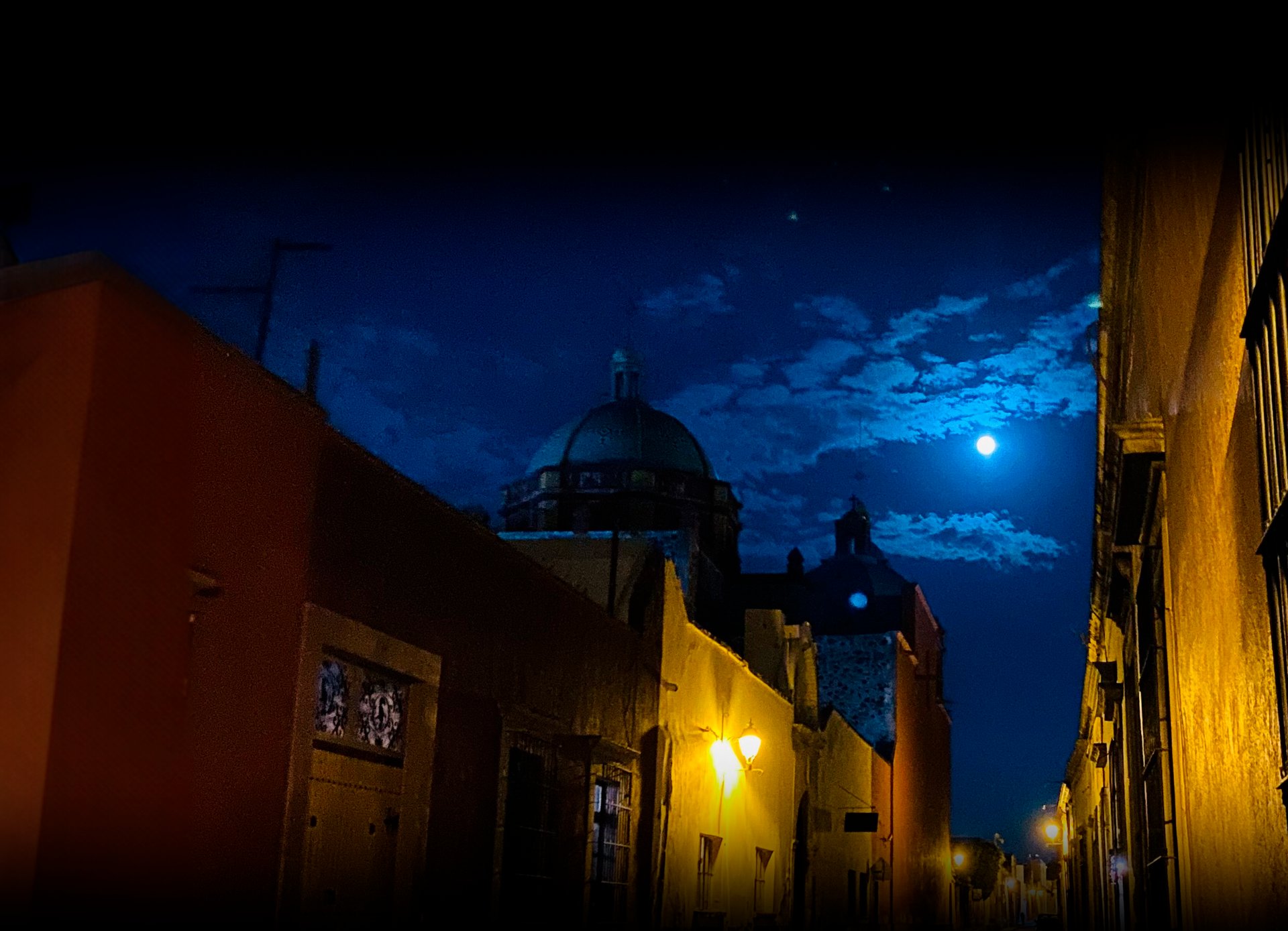 an abstract photo of a curved building with a blue sky in the background