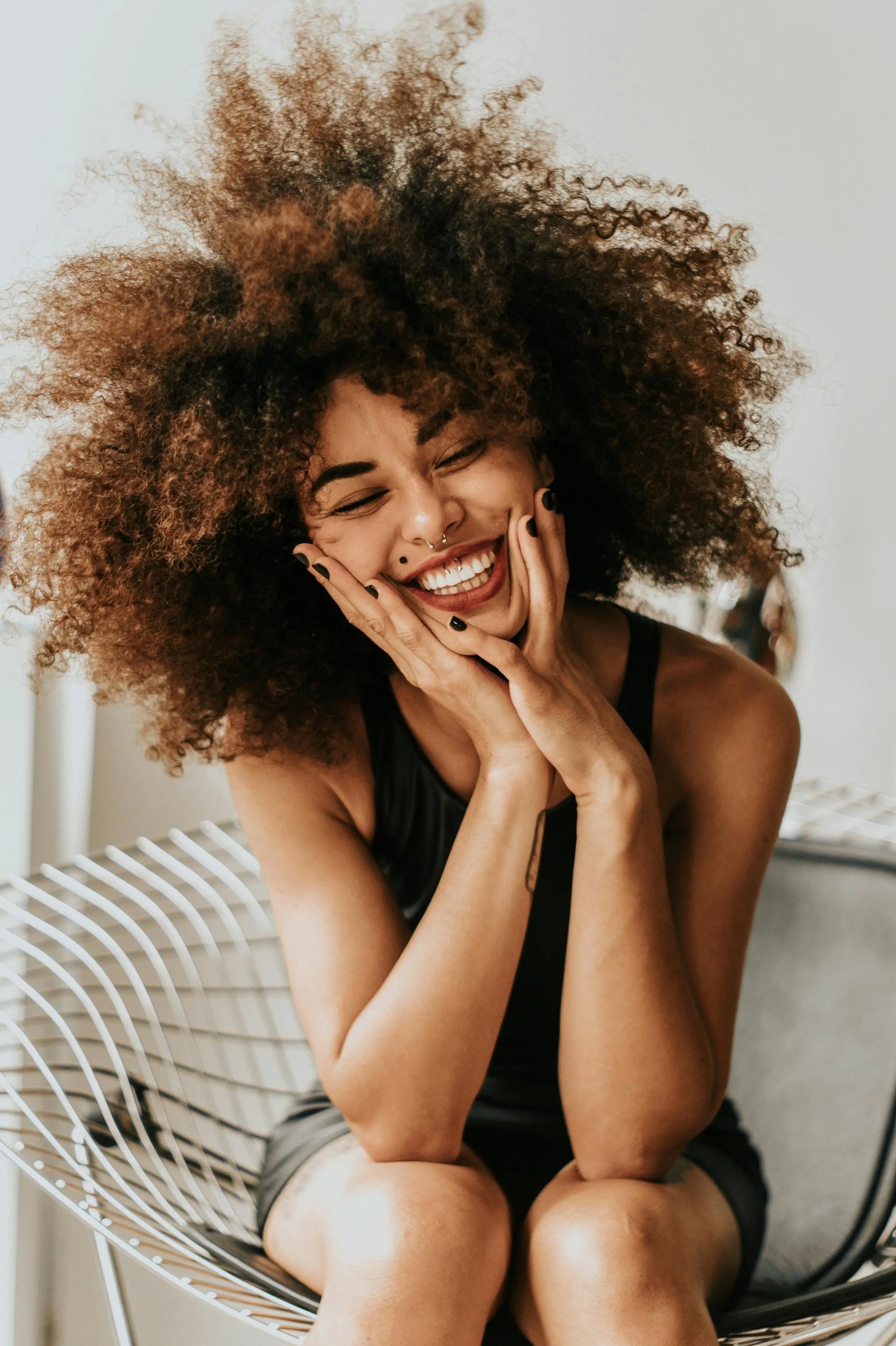 a woman with a curly afro hairs and a black dress