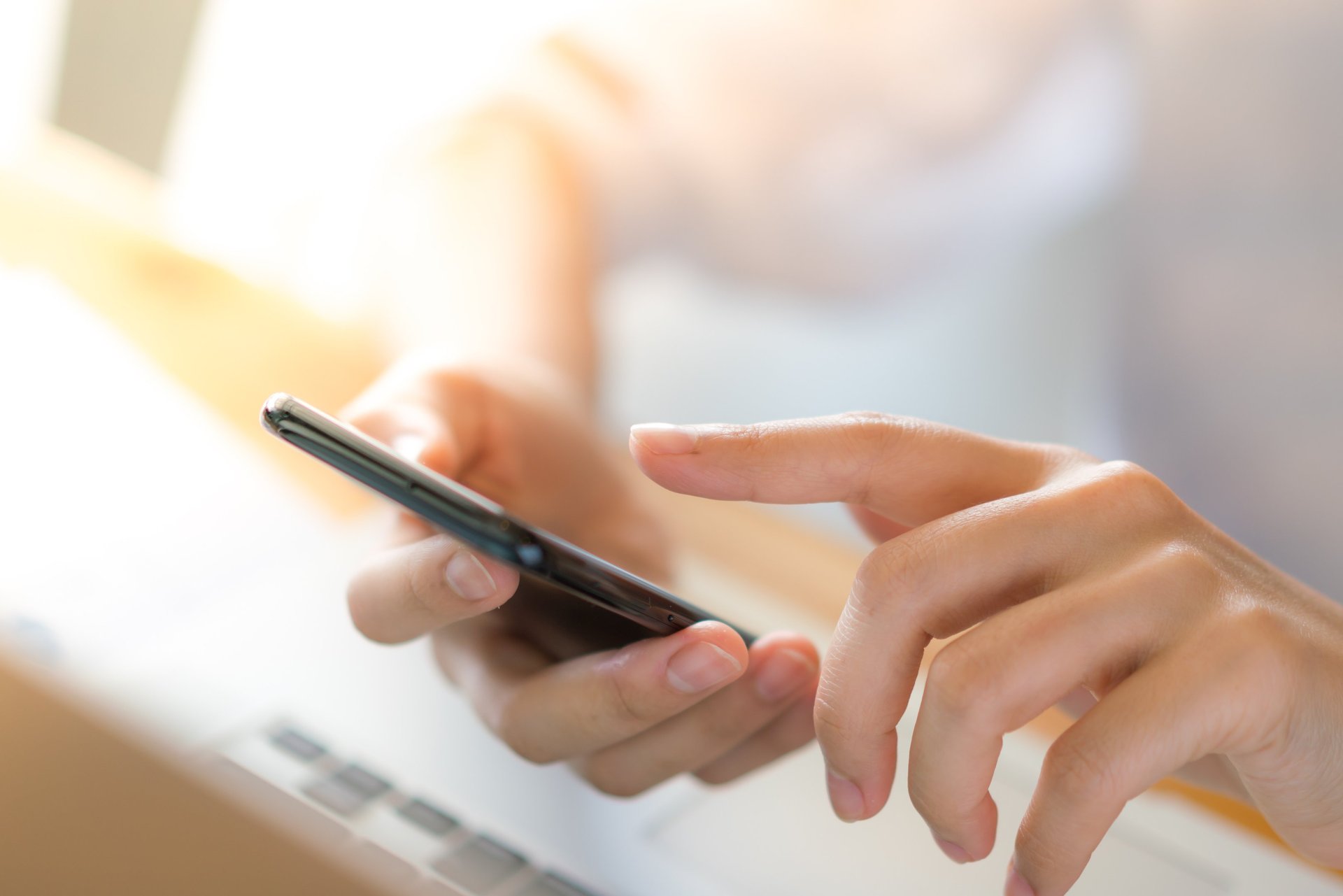 woman in white sleeveless dress holding silver iphone 6