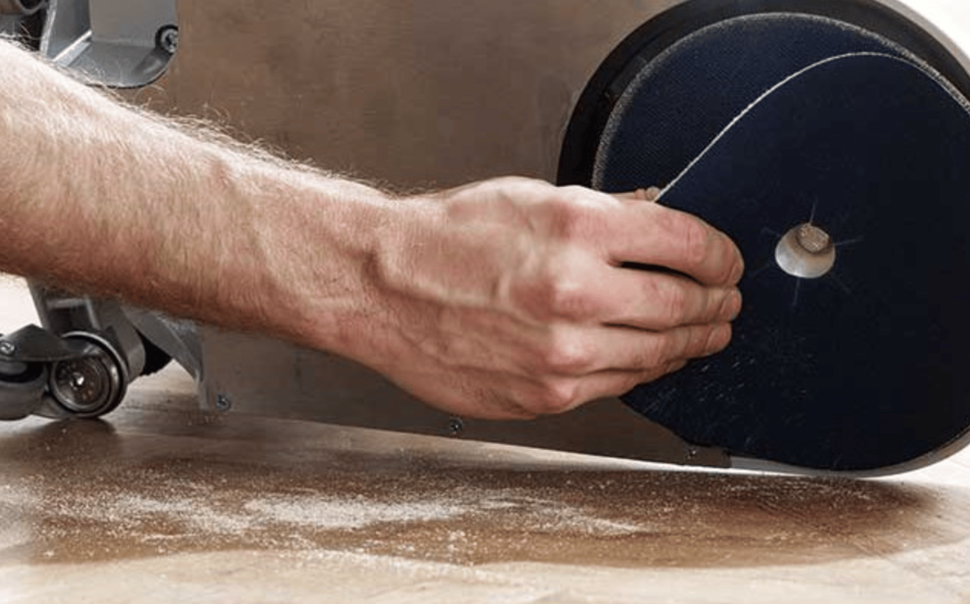 person in white shirt holding brown wooden table