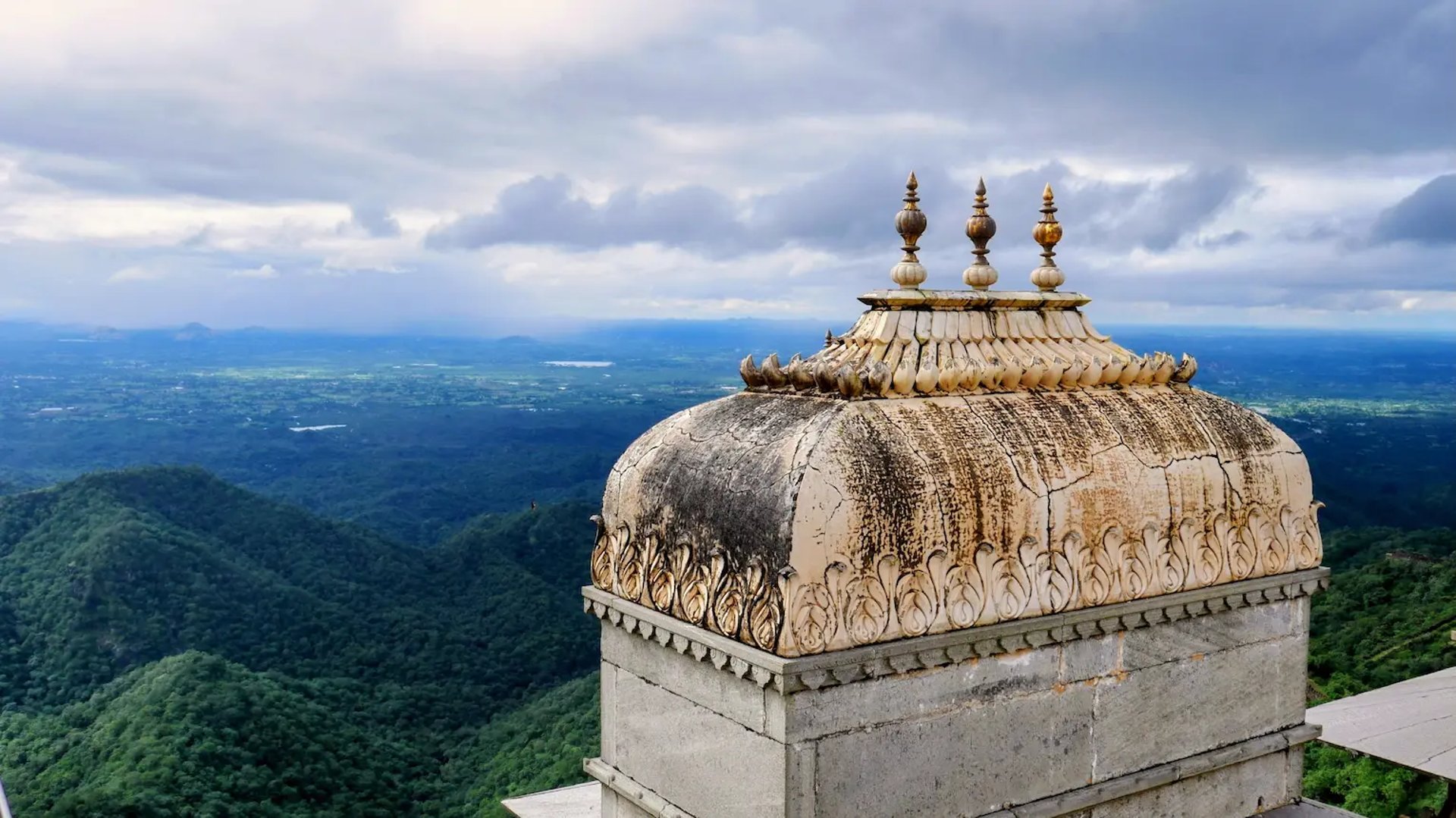 Panoramic view from Kumbhalgarh Fort featuring a historic temple dome overlooking the vast Aravalli hills.