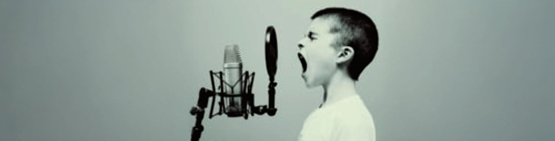 boy singing on microphone with pop filter