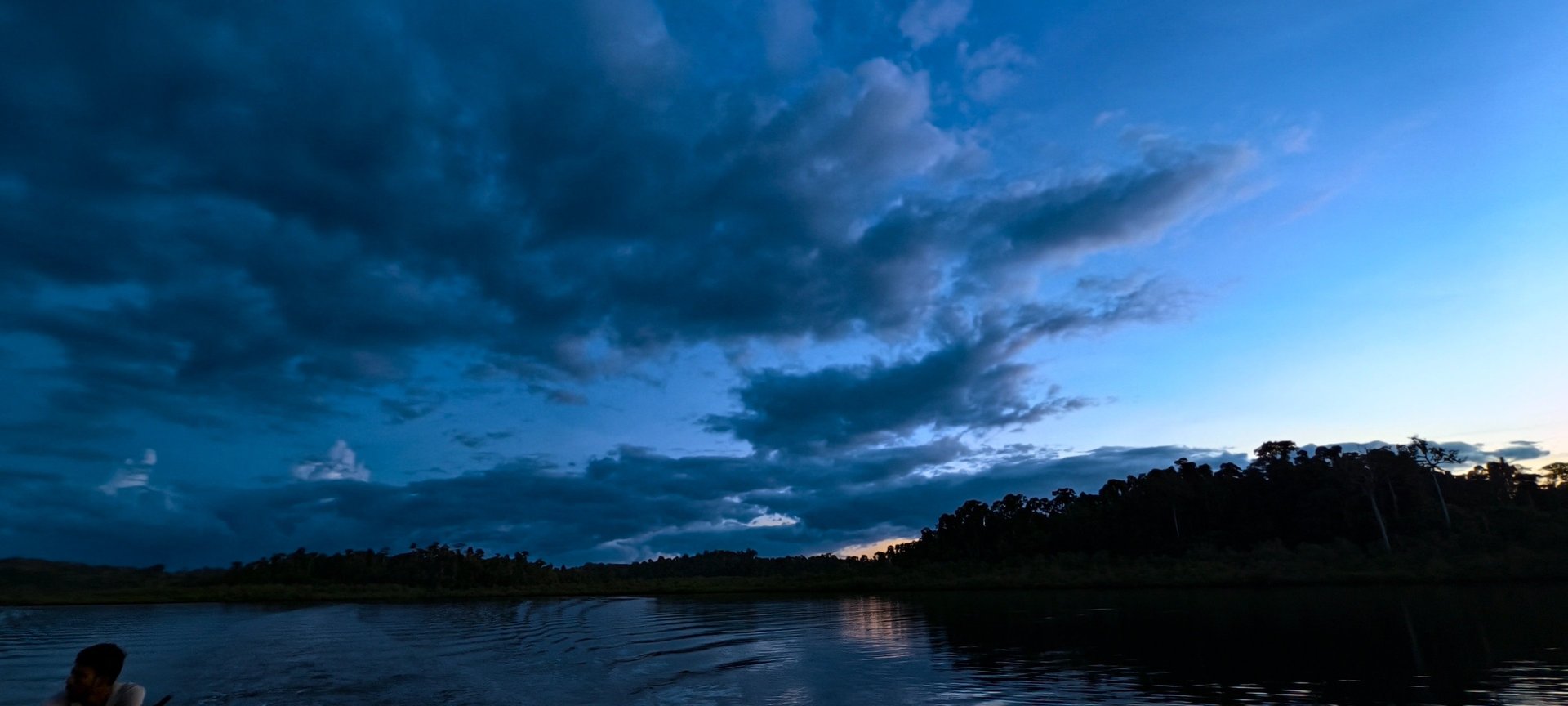 brown wooden house near lake surrounded by green trees during daytime