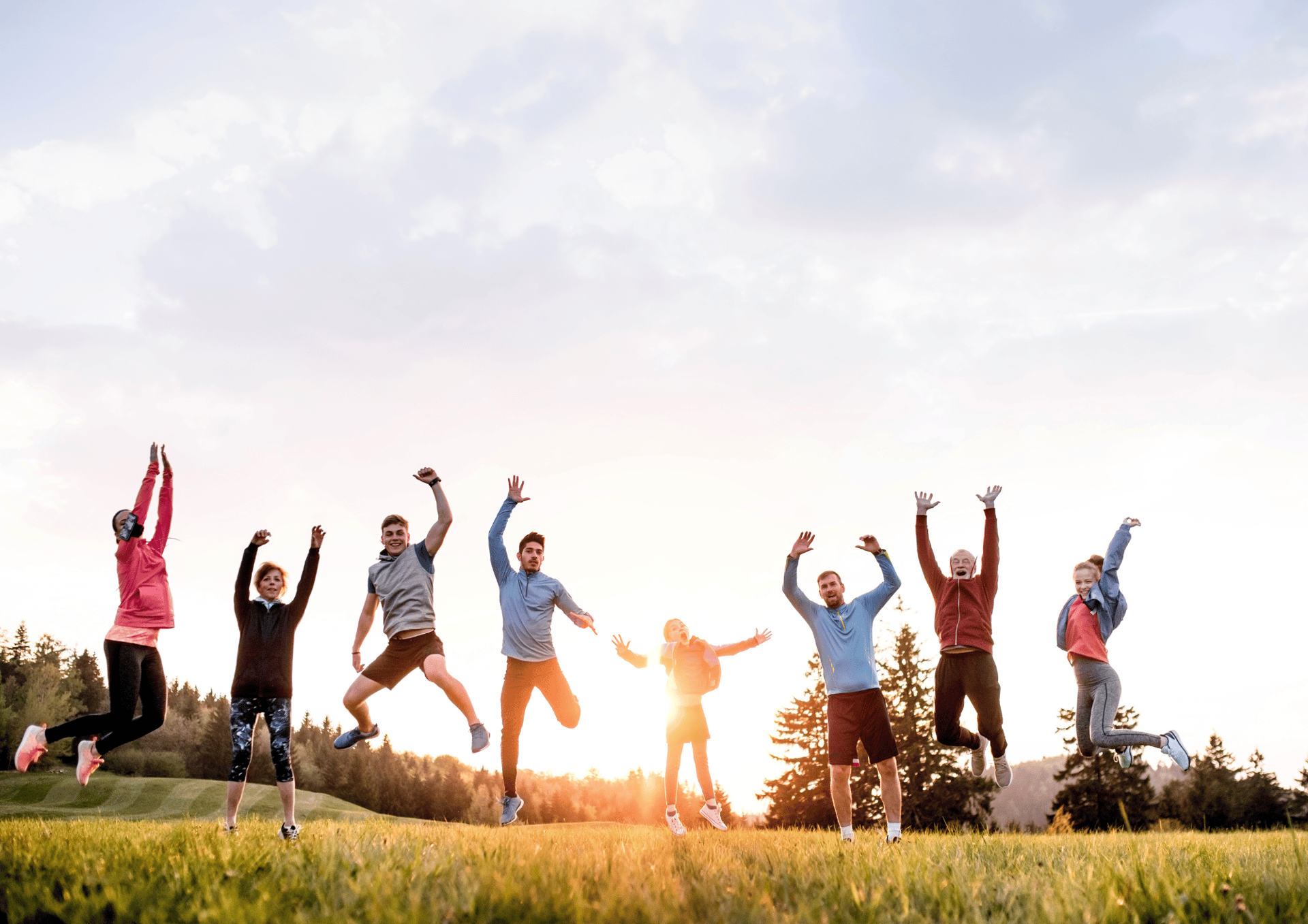 four person hands wrap around shoulders while looking at sunset