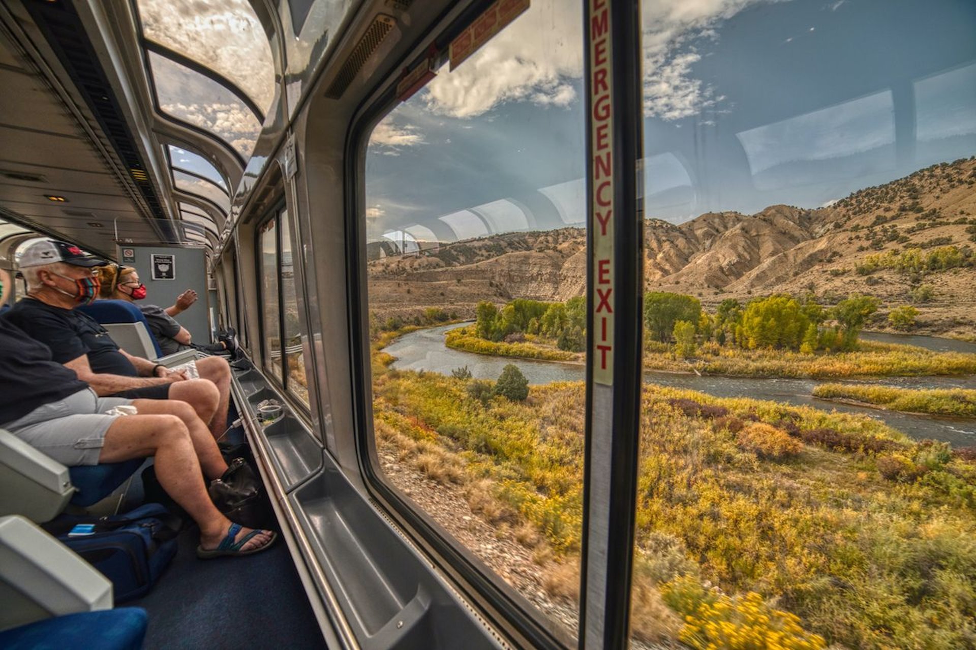 gray and blue train passing near body of water