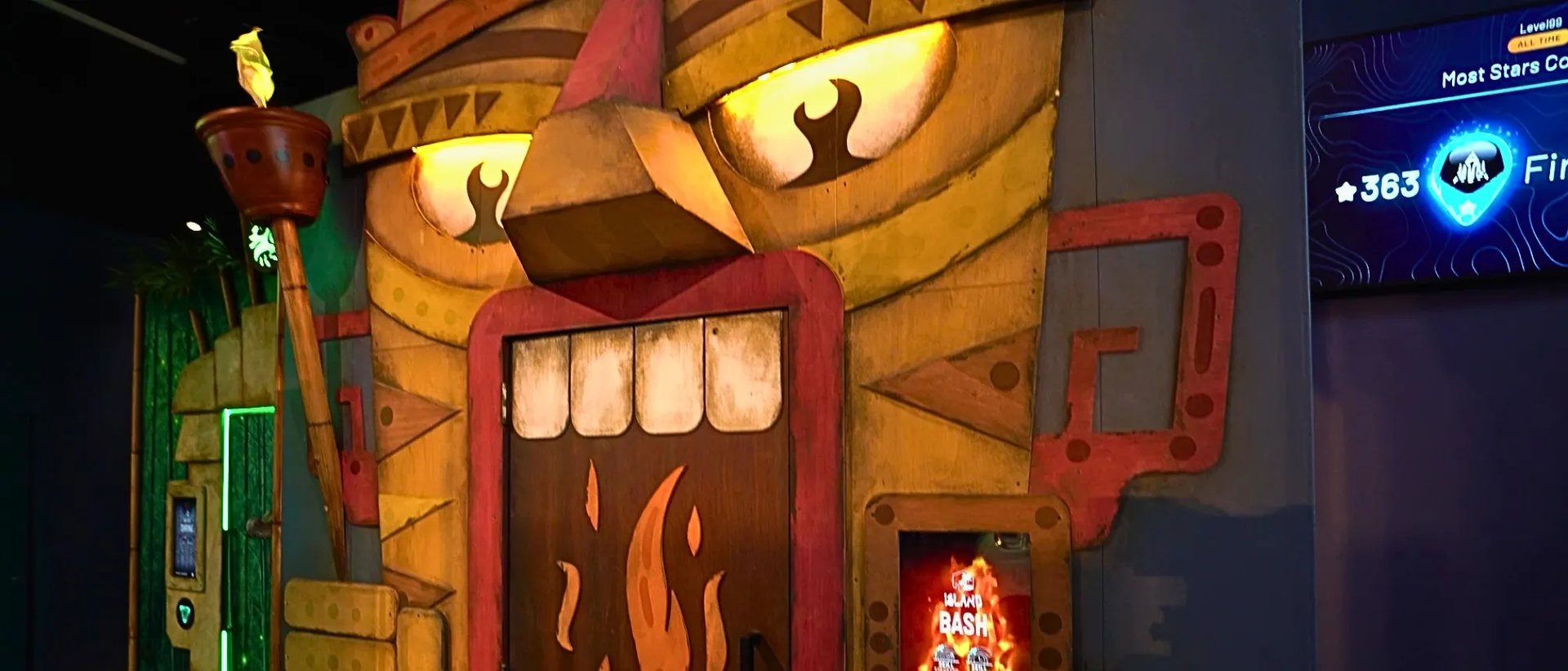 Tiki mask doorway at Level 99 Disney Springs with glowing yellow eyes and tribal carvings.
