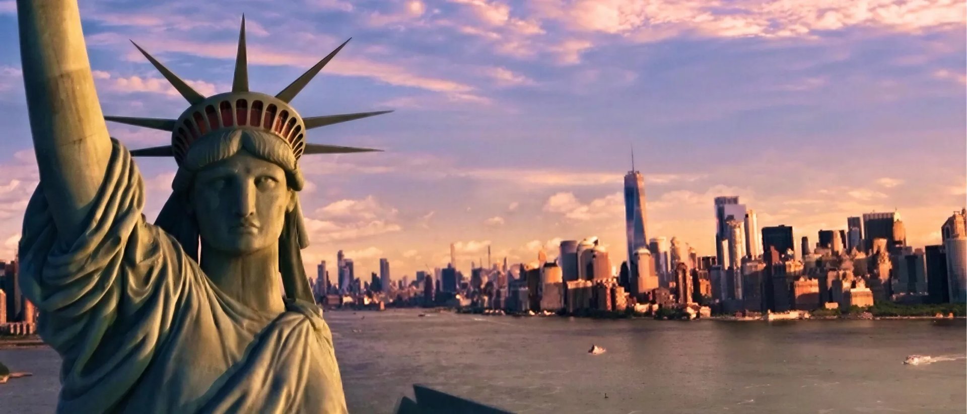 Cinematic view of the Statue of Liberty overlooking the New York City skyline at sunset for Soarin' Across America.