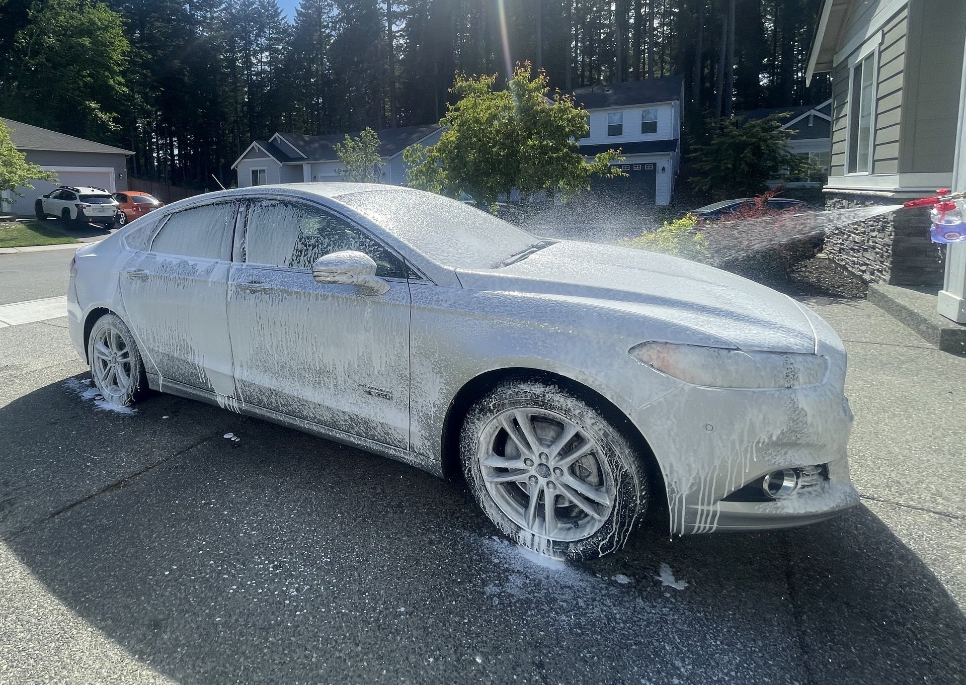 a person holding a gun next to a car that is on a brick road