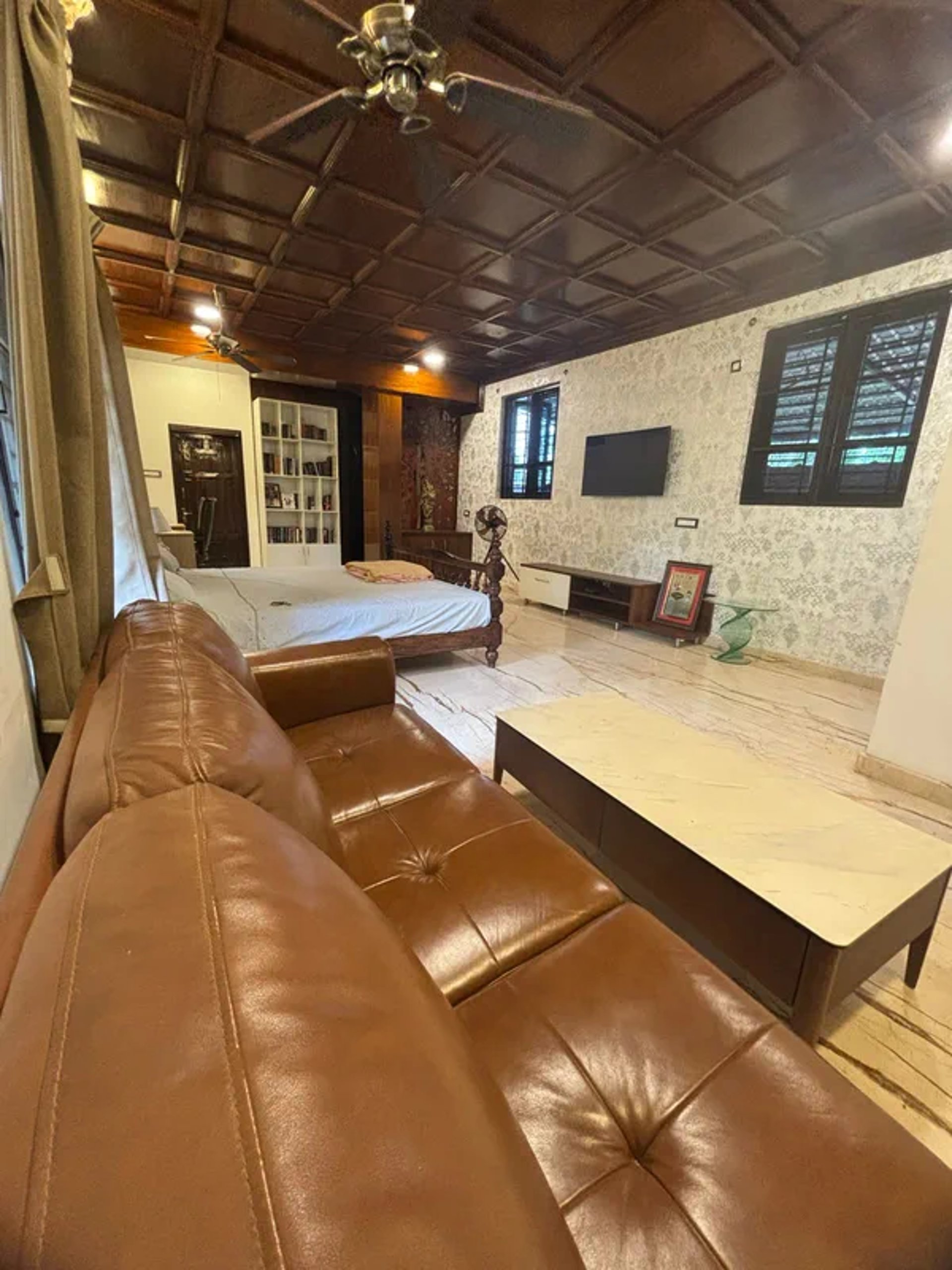 black leather padded armchair near black wooden framed glass window