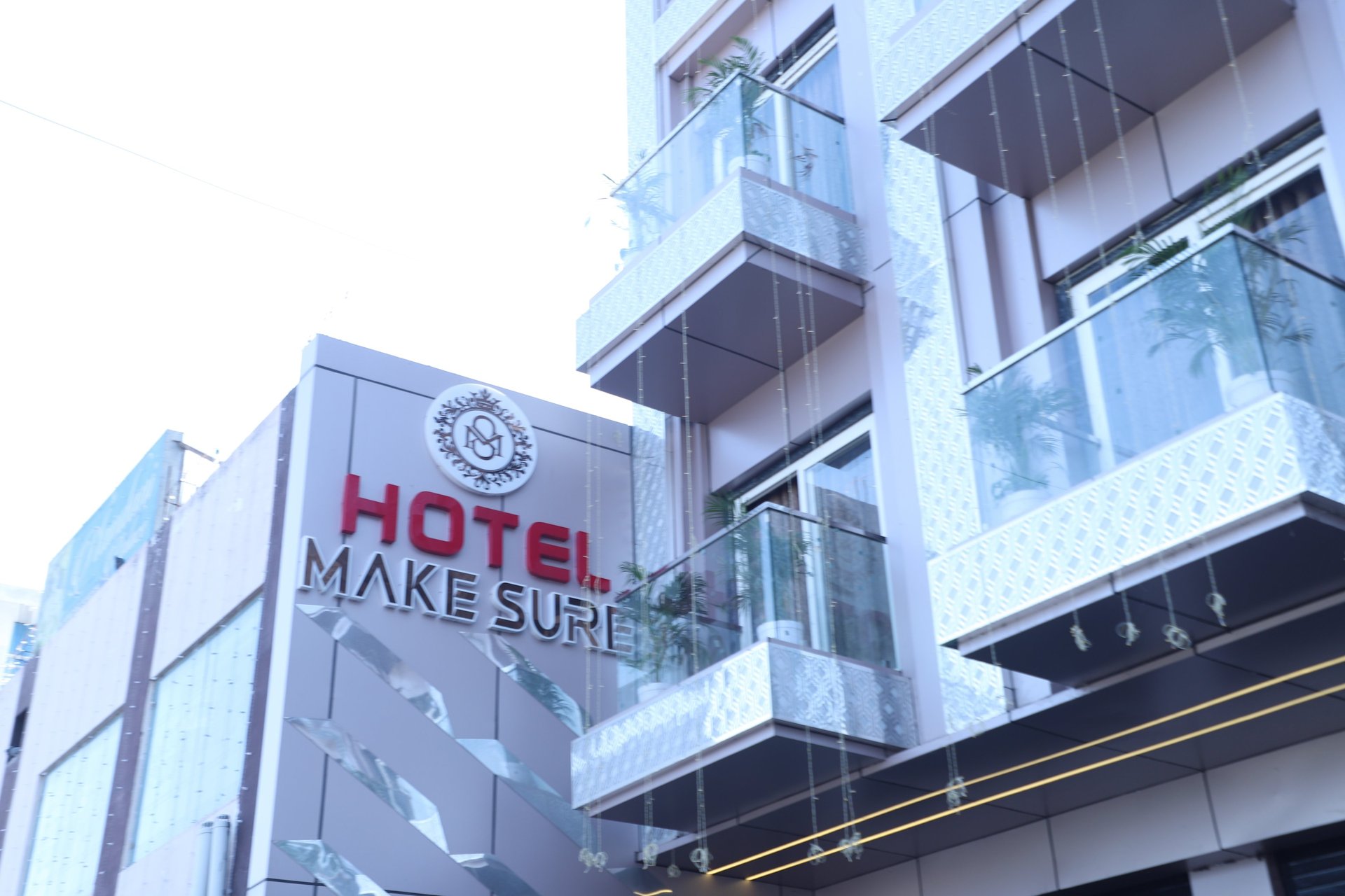 low-angle photo of Hotel lighted signage on top of brown building during nighttime