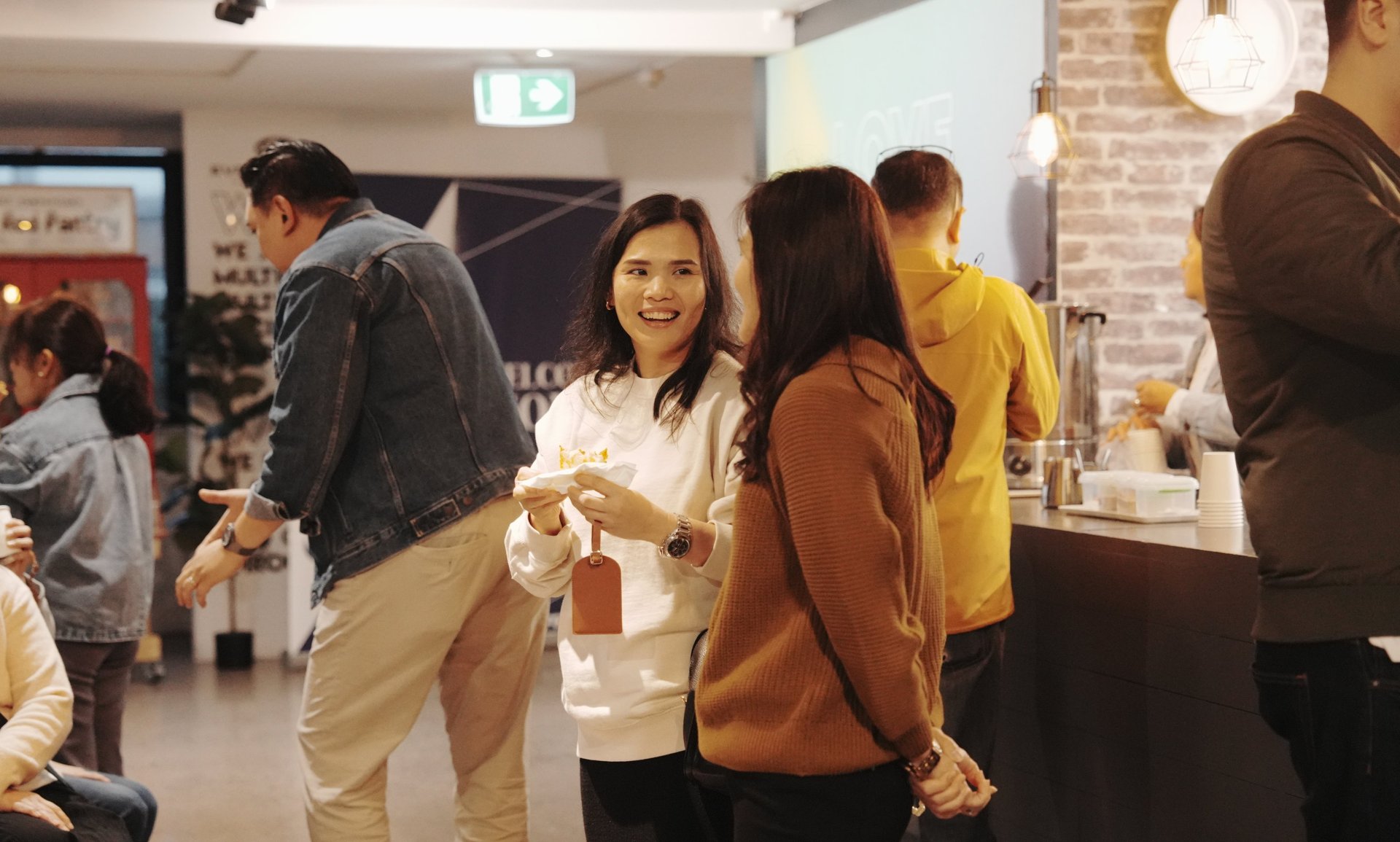 Four friends smiling in a park during autumn