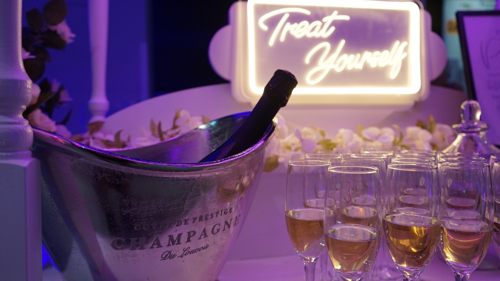 a table set with white flowers and greenery