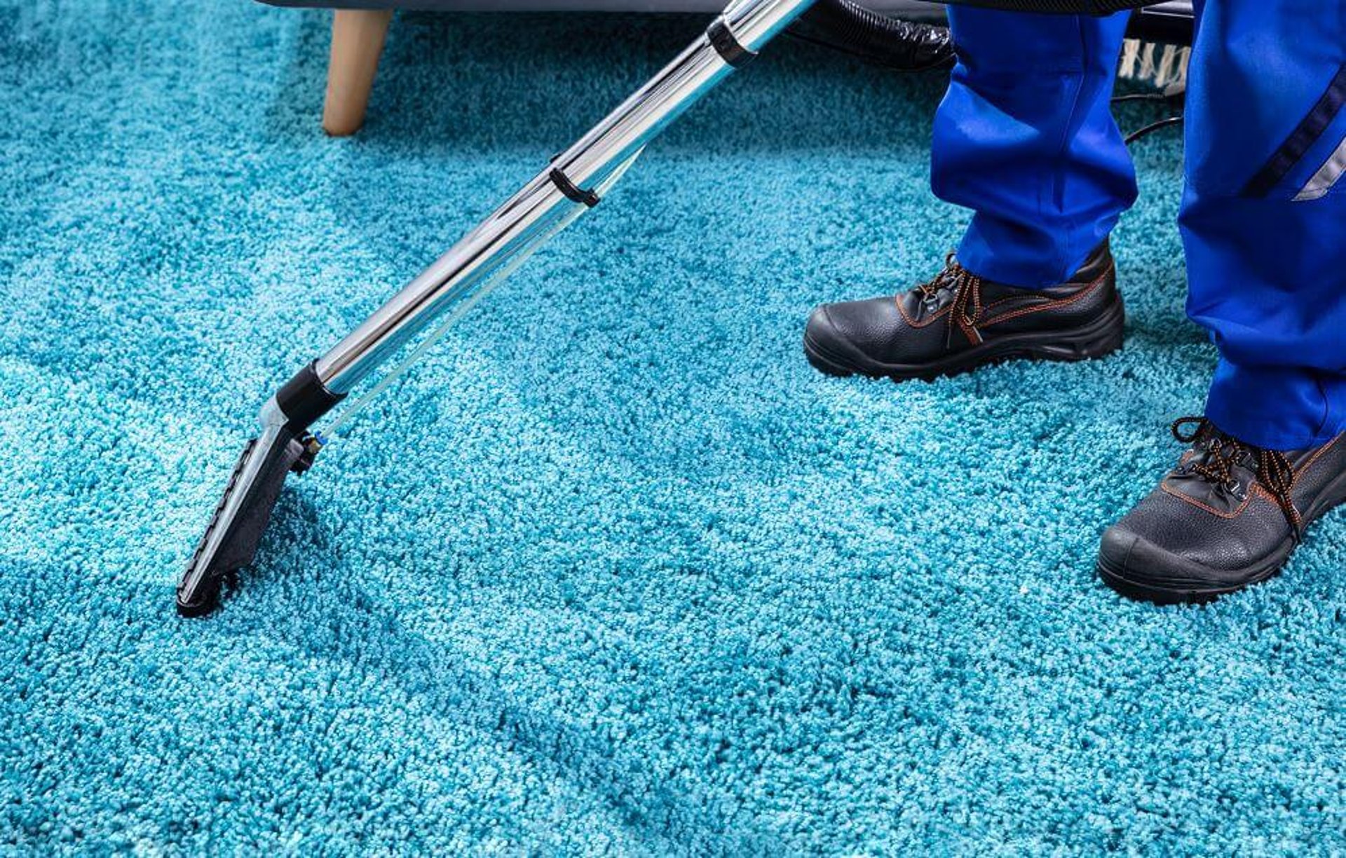 A man sanding a wooden table with a sander