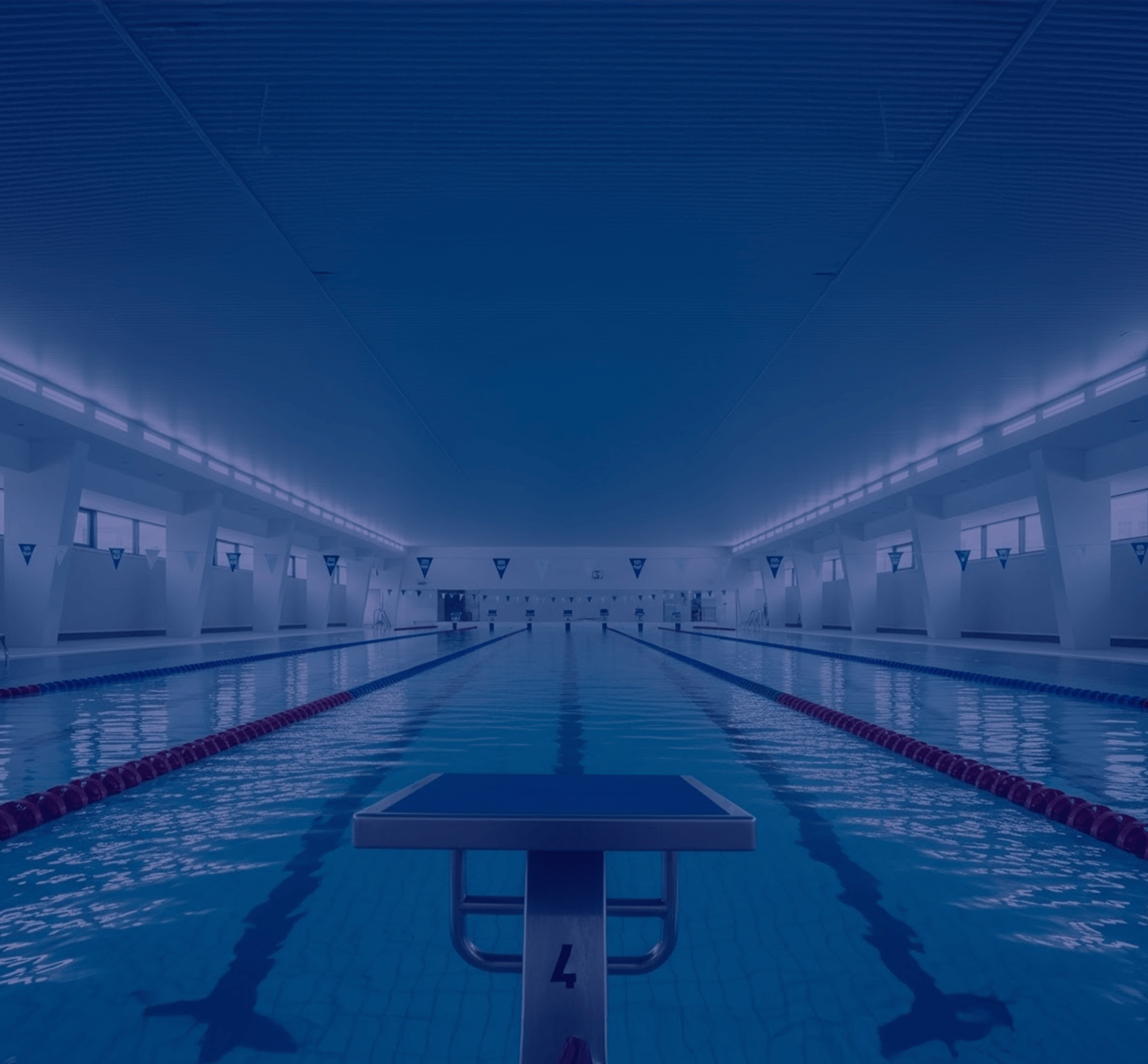 an empty swimming pool with a tall building in the background