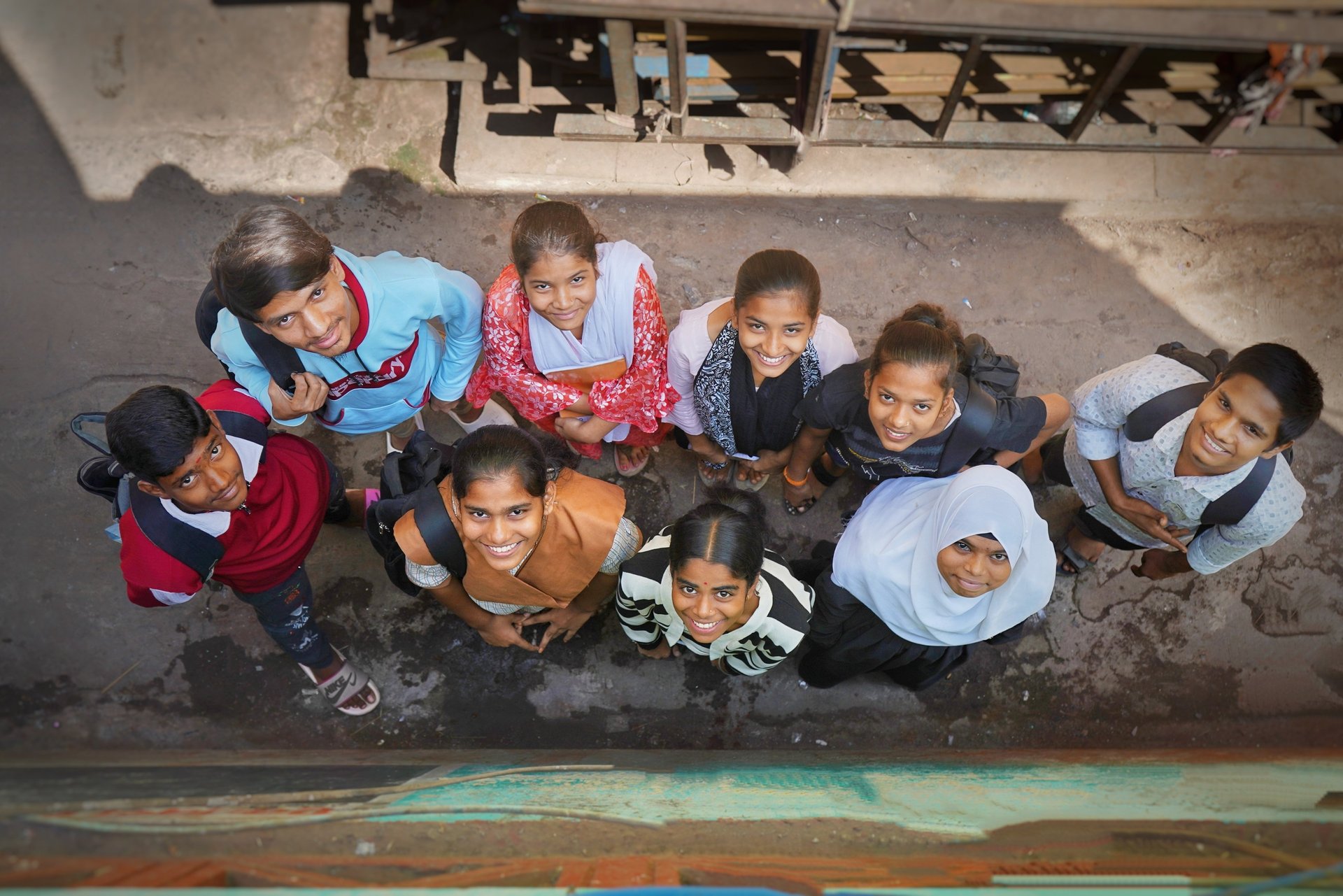 man in orange shirt writing on white paper