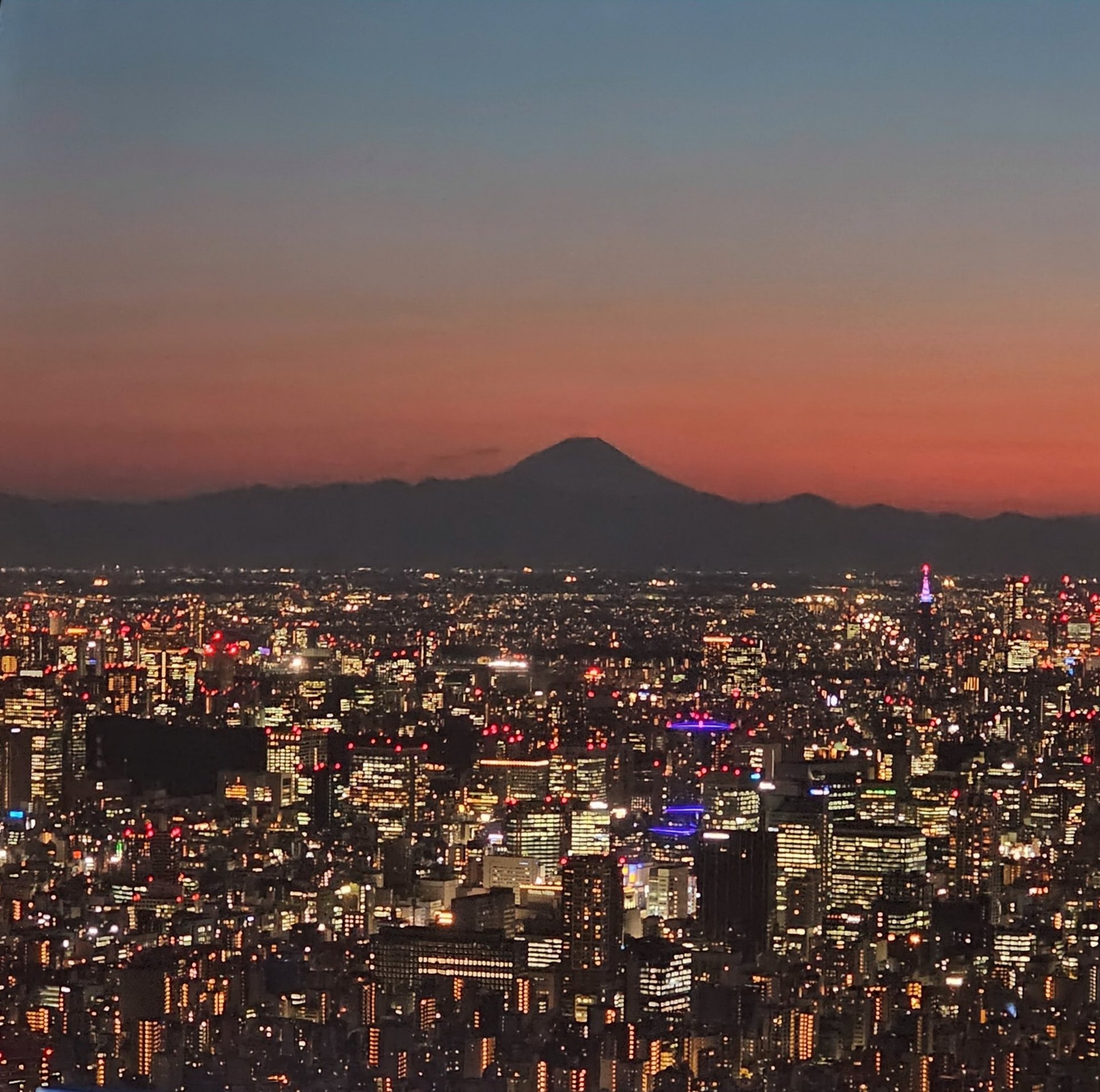 A rainbow waterfall is lit up at night