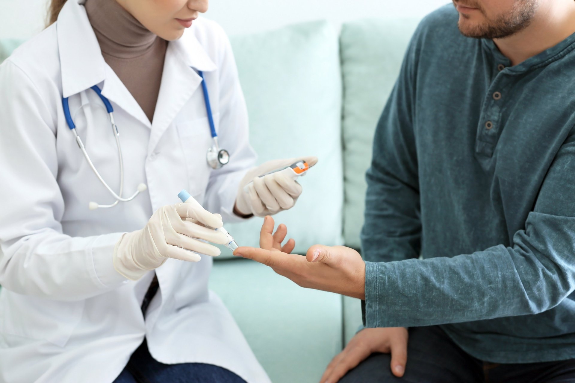 three men's sitting on white concrete bollard near body of water during daytime