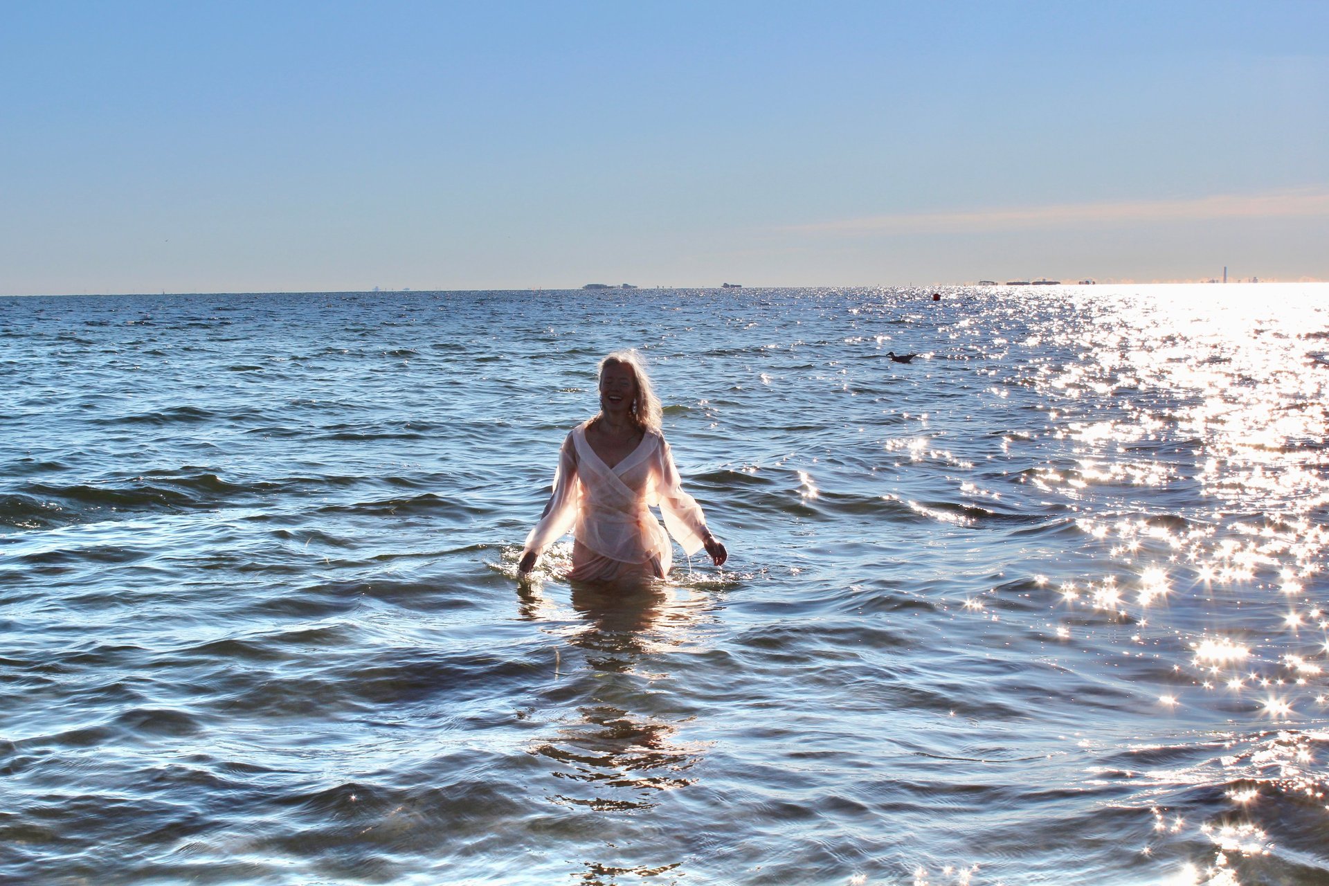 woman wearing yellow long-sleeved dress under white clouds and blue sky during daytime