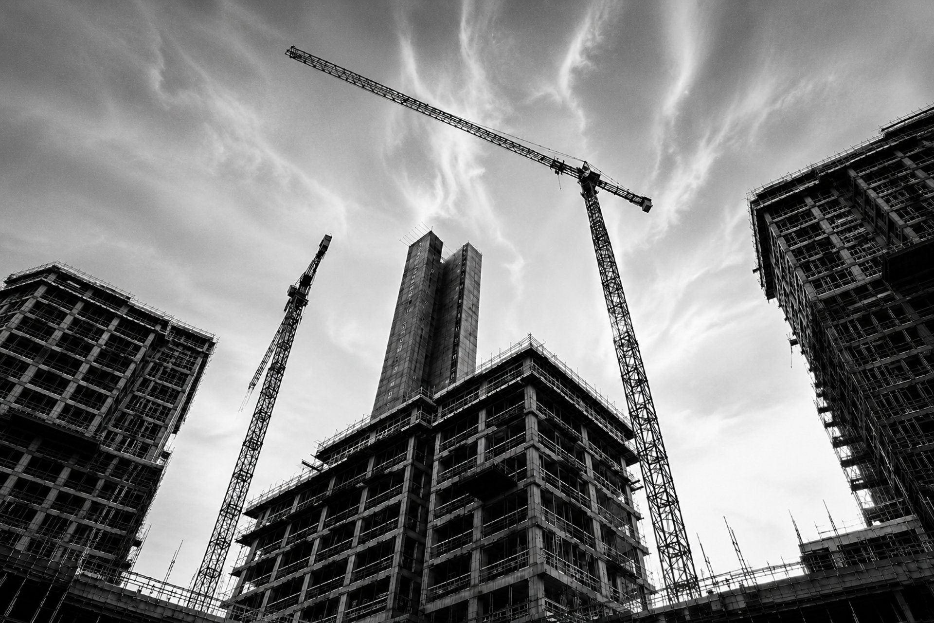 grayscale photo of crane in front of building