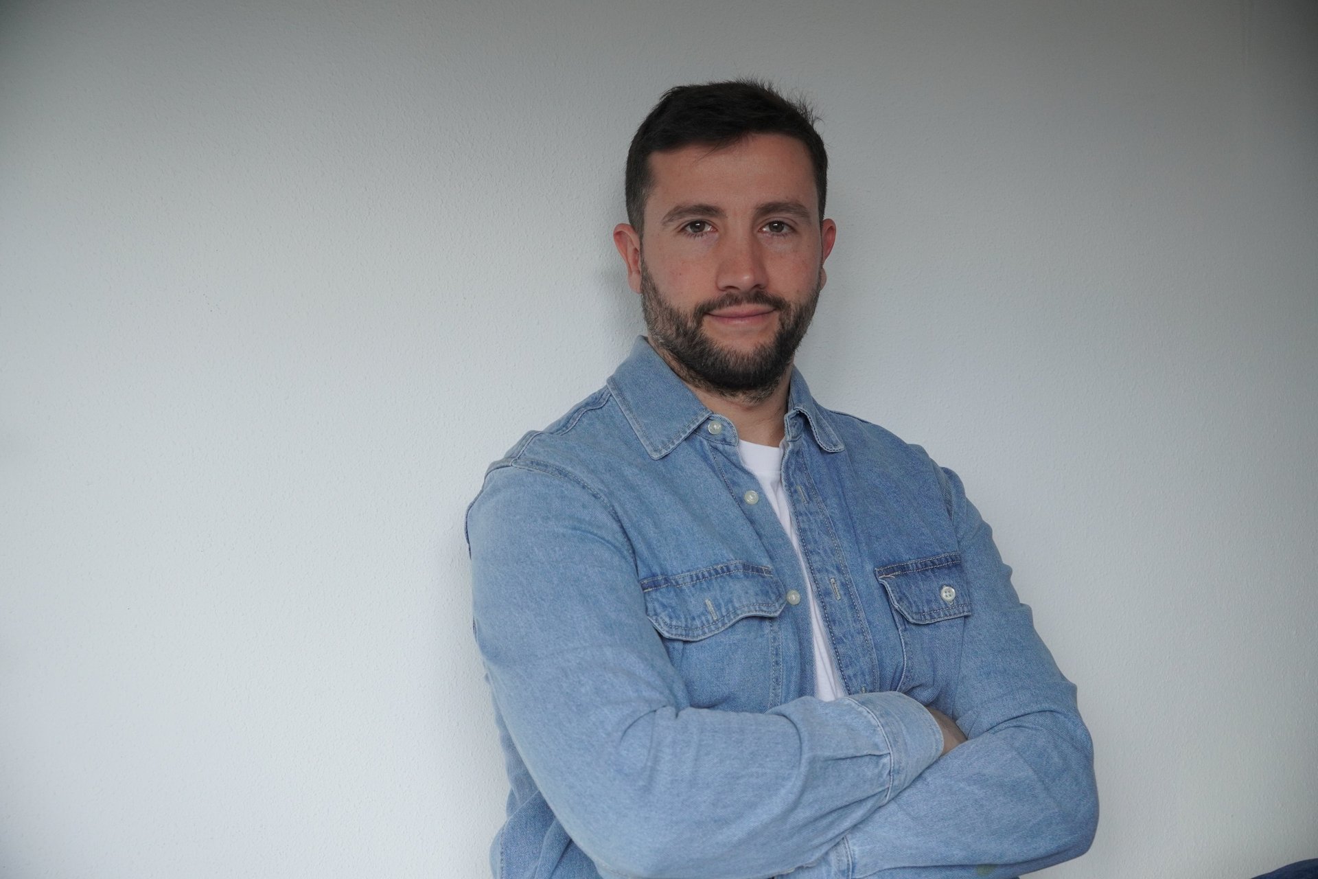 three men sitting while using laptops and watching man beside whiteboard