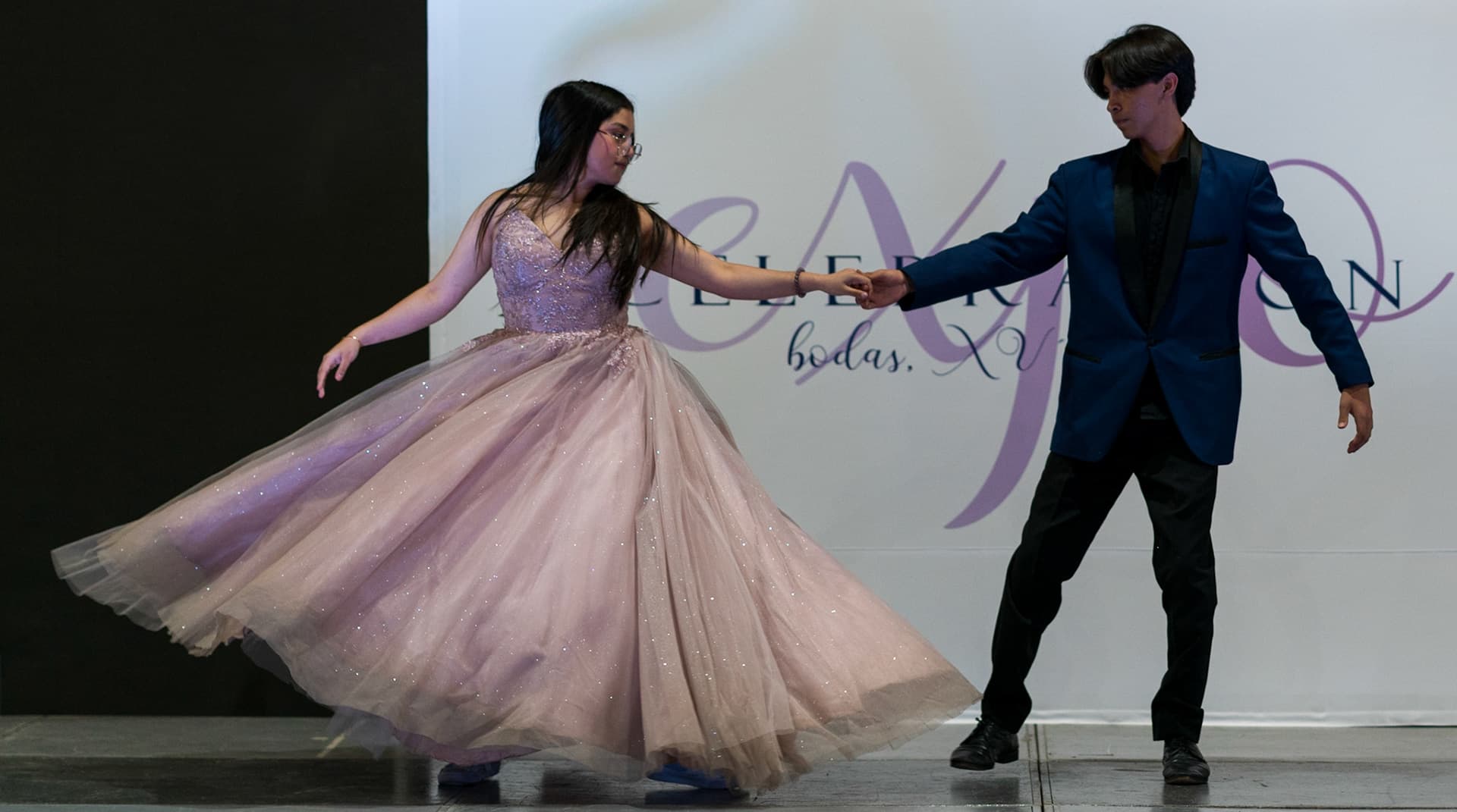 mujer con vestido de quince años bailando con hombre en pasarela