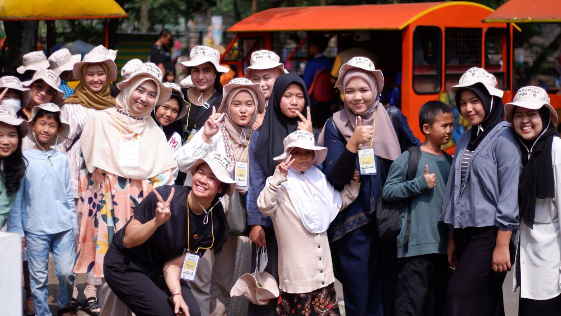 five children smiling while doing peace hand sign