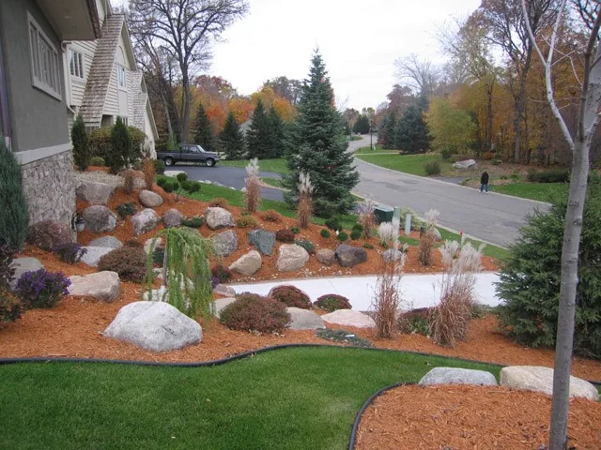 man in orange jacket sitting on yellow and black tractor