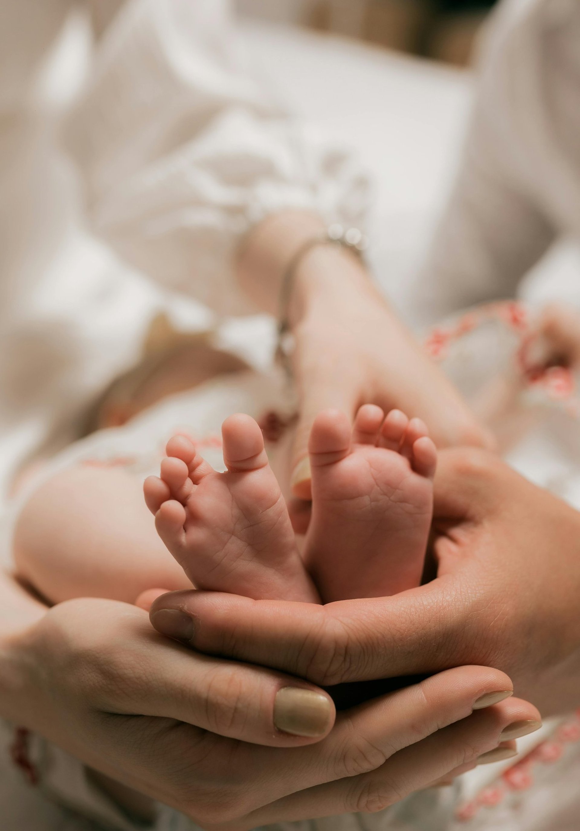Petits pieds d'enfant entourés par les mains de ses parents