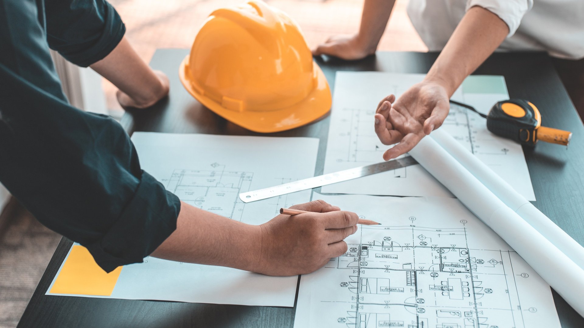 a person wearing a hard hat and looking at a tablet