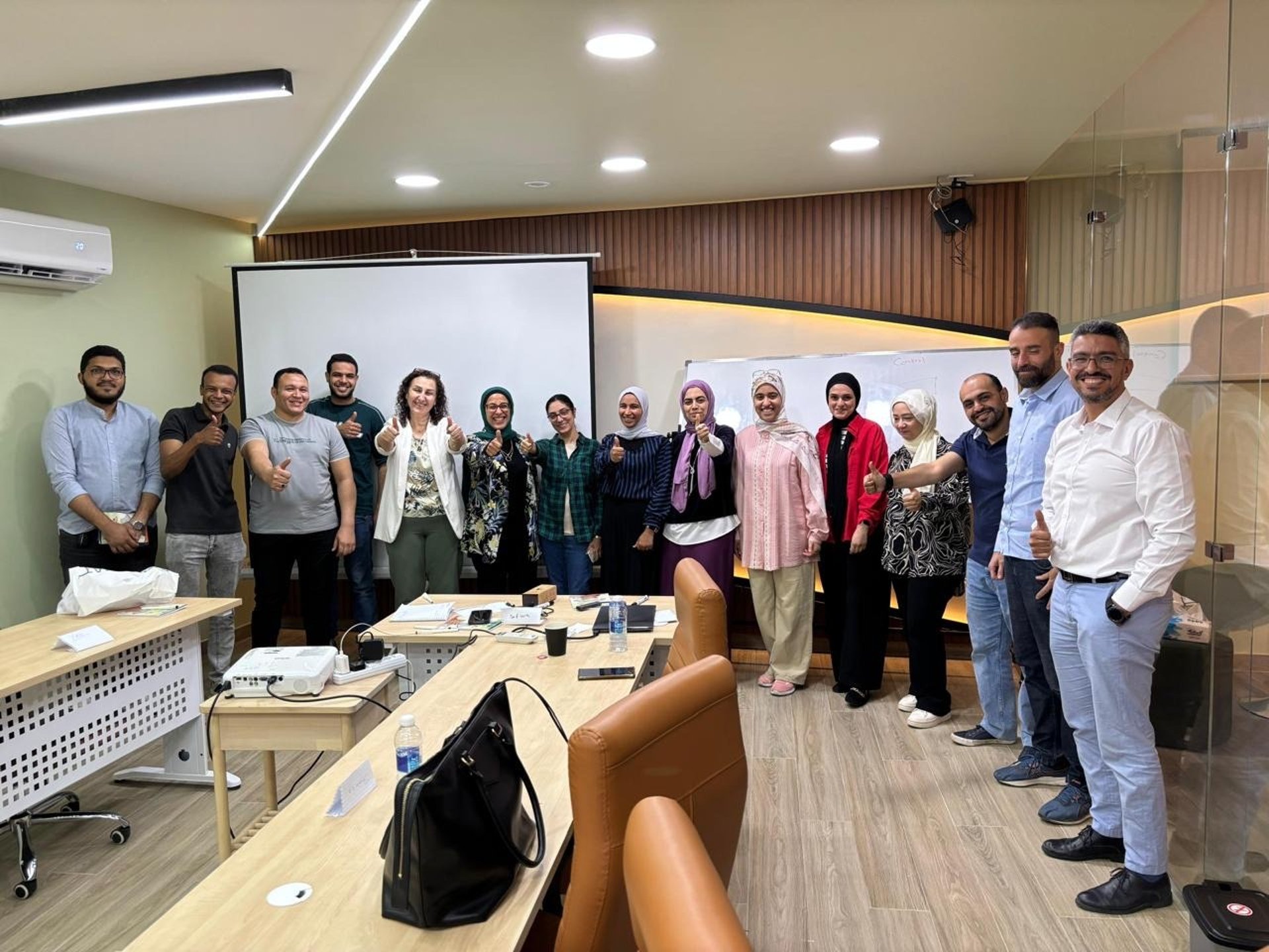 man standing in front of people sitting beside table with laptop computers
