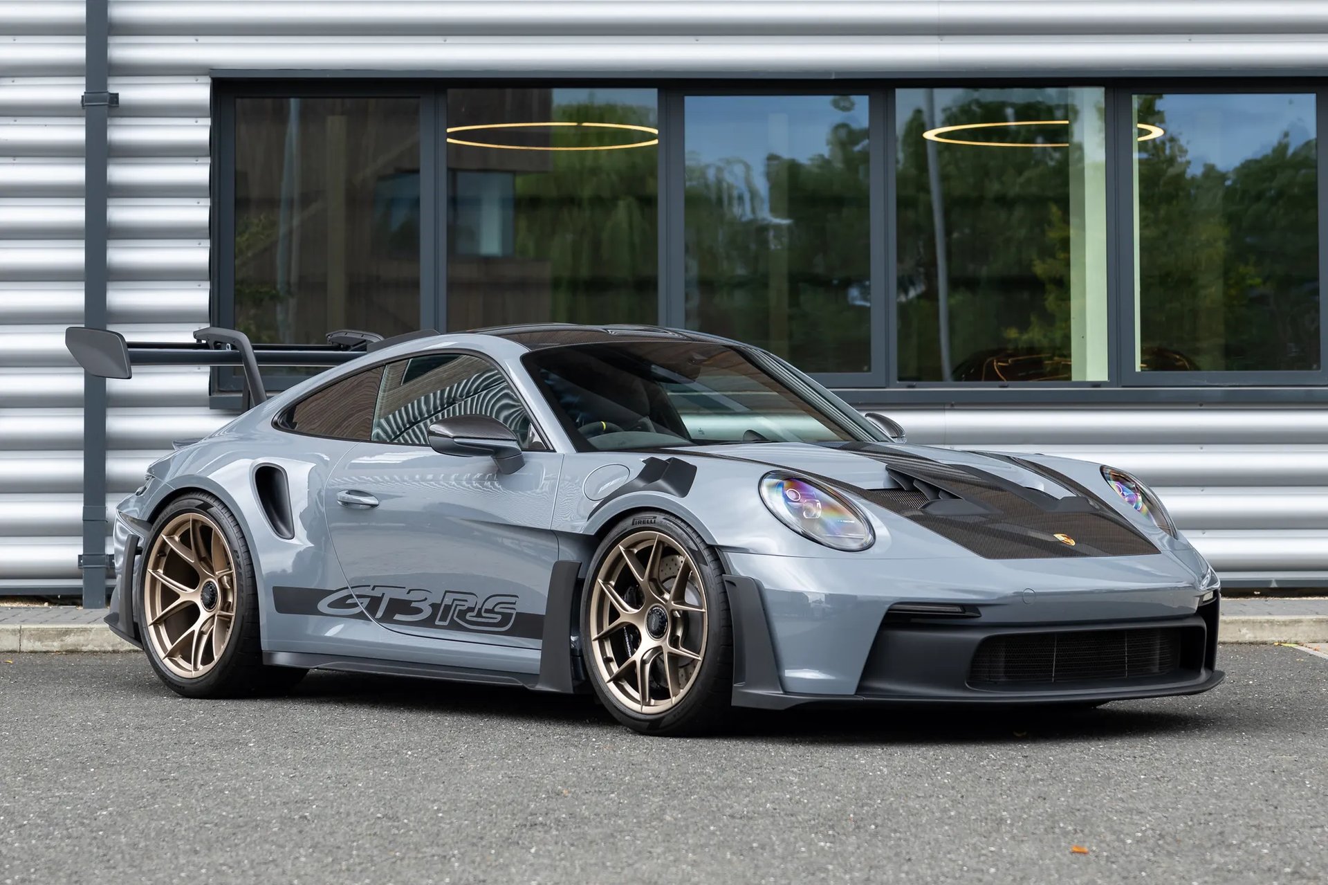 a grey porsche gtr parked in front of a building