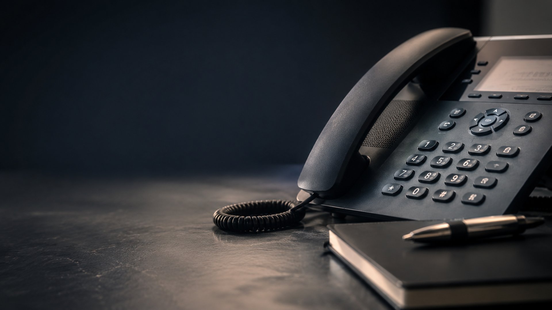 black and brown rotary phone near gray wall
