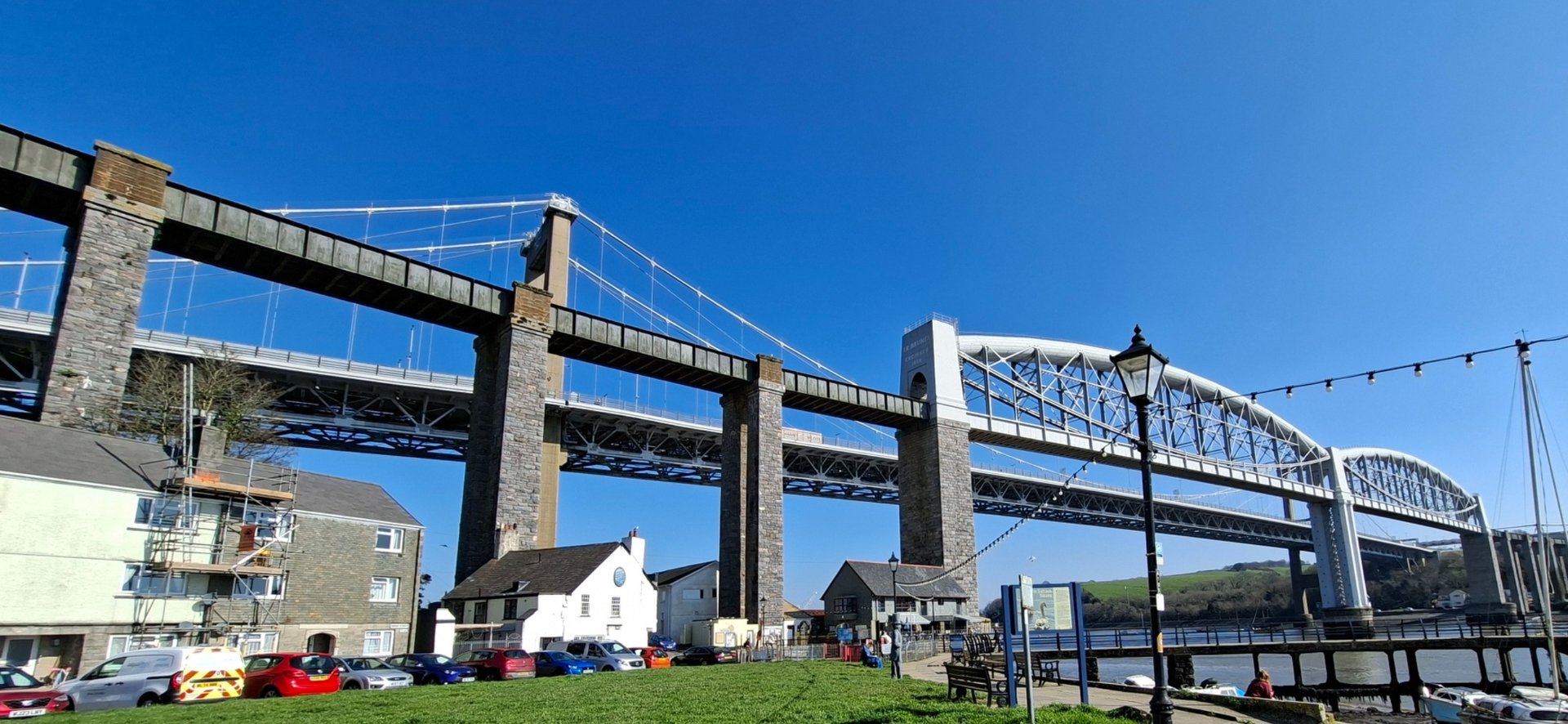 brown wooden house near lake surrounded by green trees during daytime