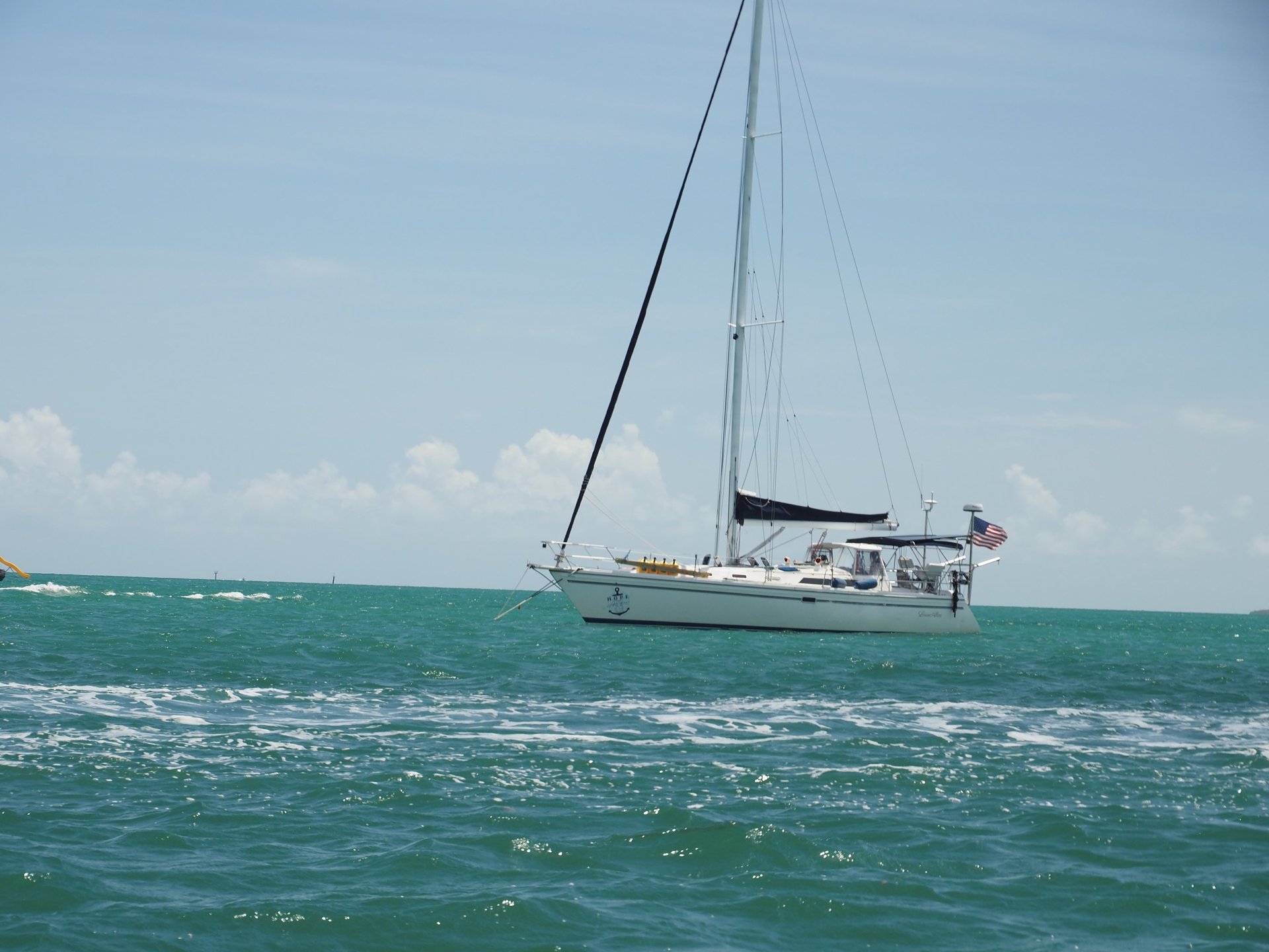 white sailboat on sea under blue sky during daytime