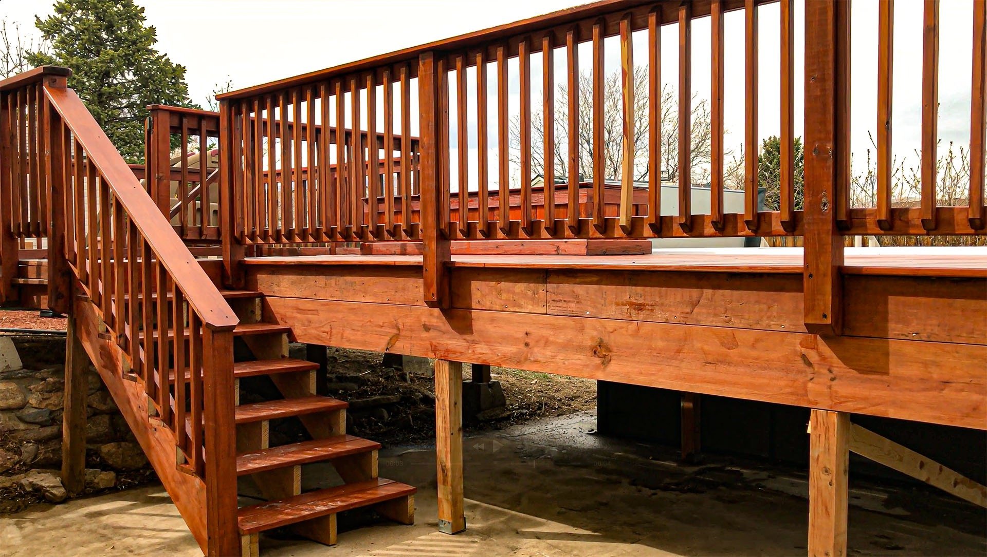 Completed residential wooden deck with stairs leading to a yard, built by Brewer Construction in Golden.