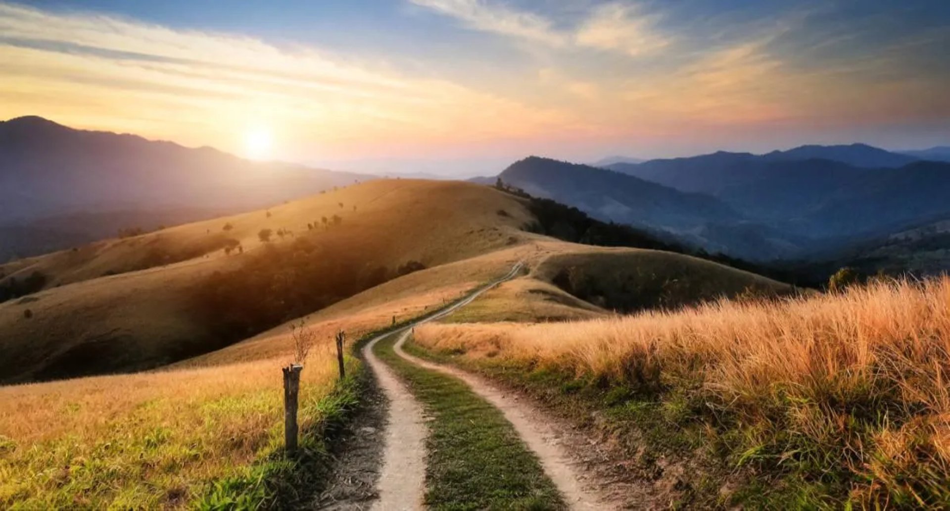 Chemin de campagne au coucher de soleil symbolisant un parcours et une évolution