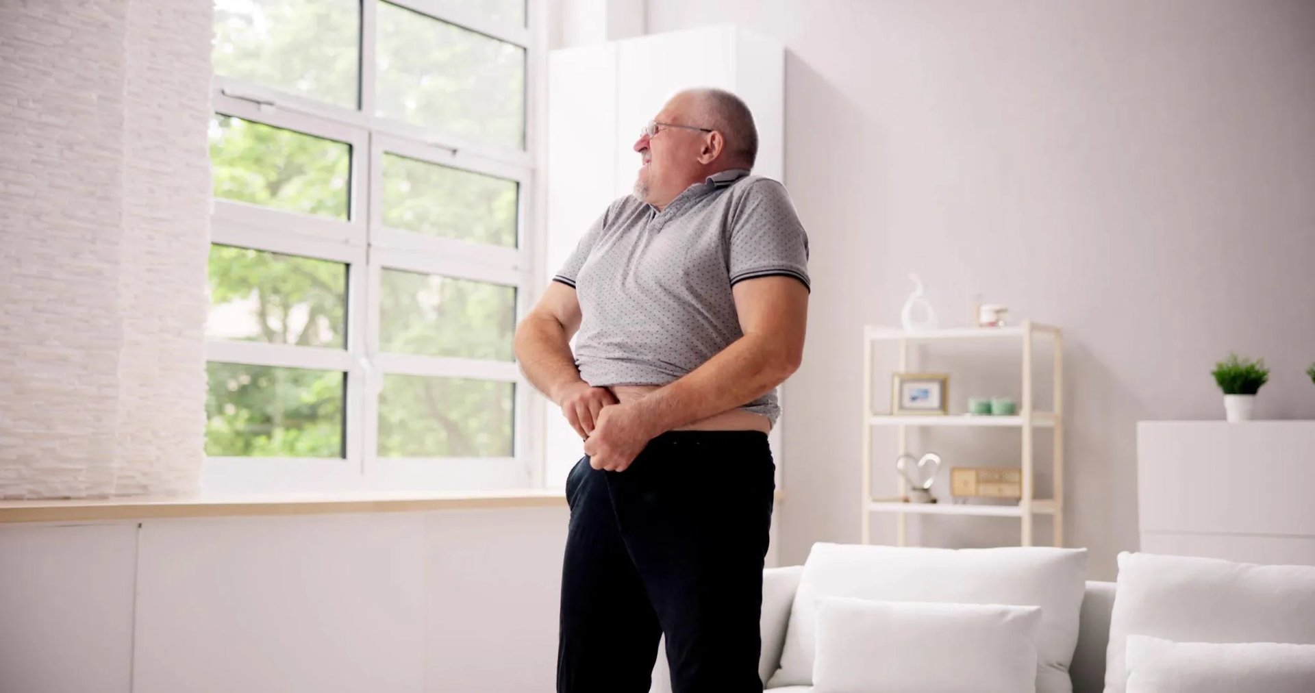 Homme en surpoids essayant de fermer son pantalon