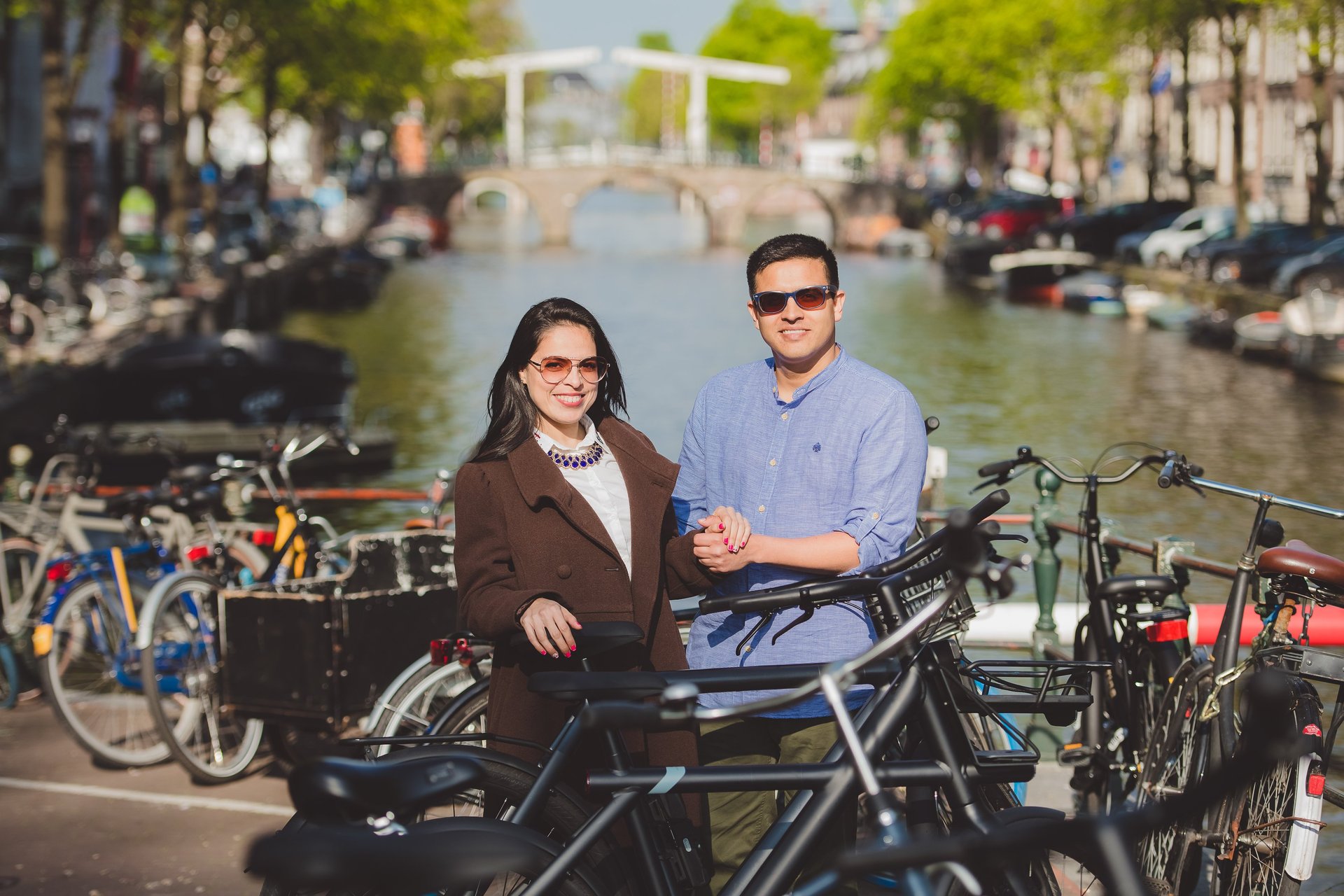 Pareja viajando por Ámsterdam junto a los canales y bicicletas