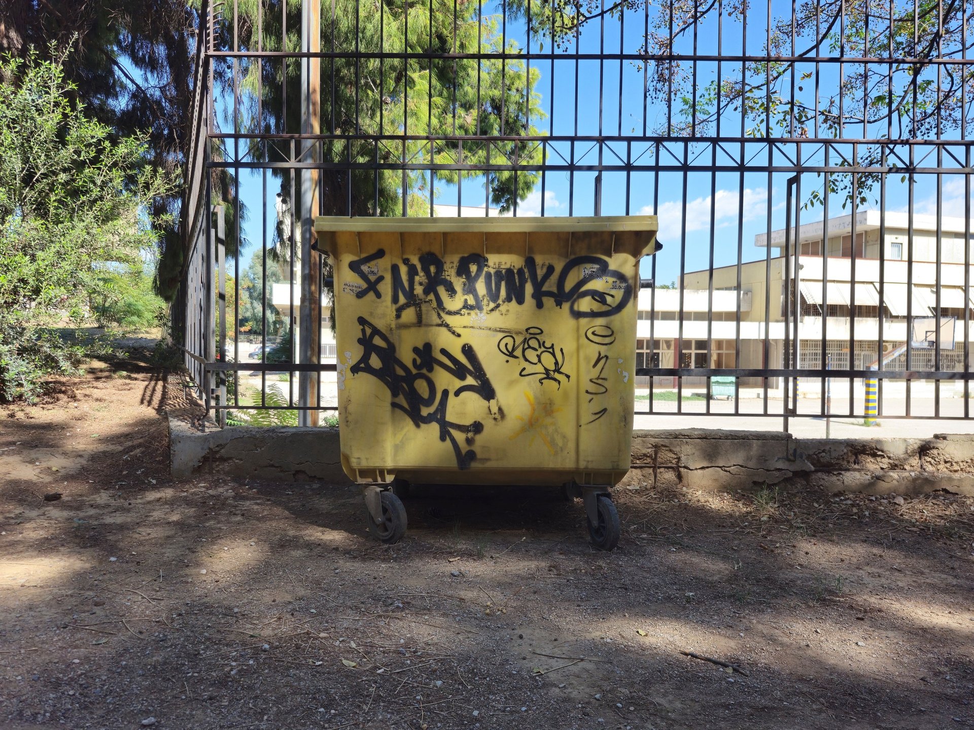 a white building with a red bucket and a broom
